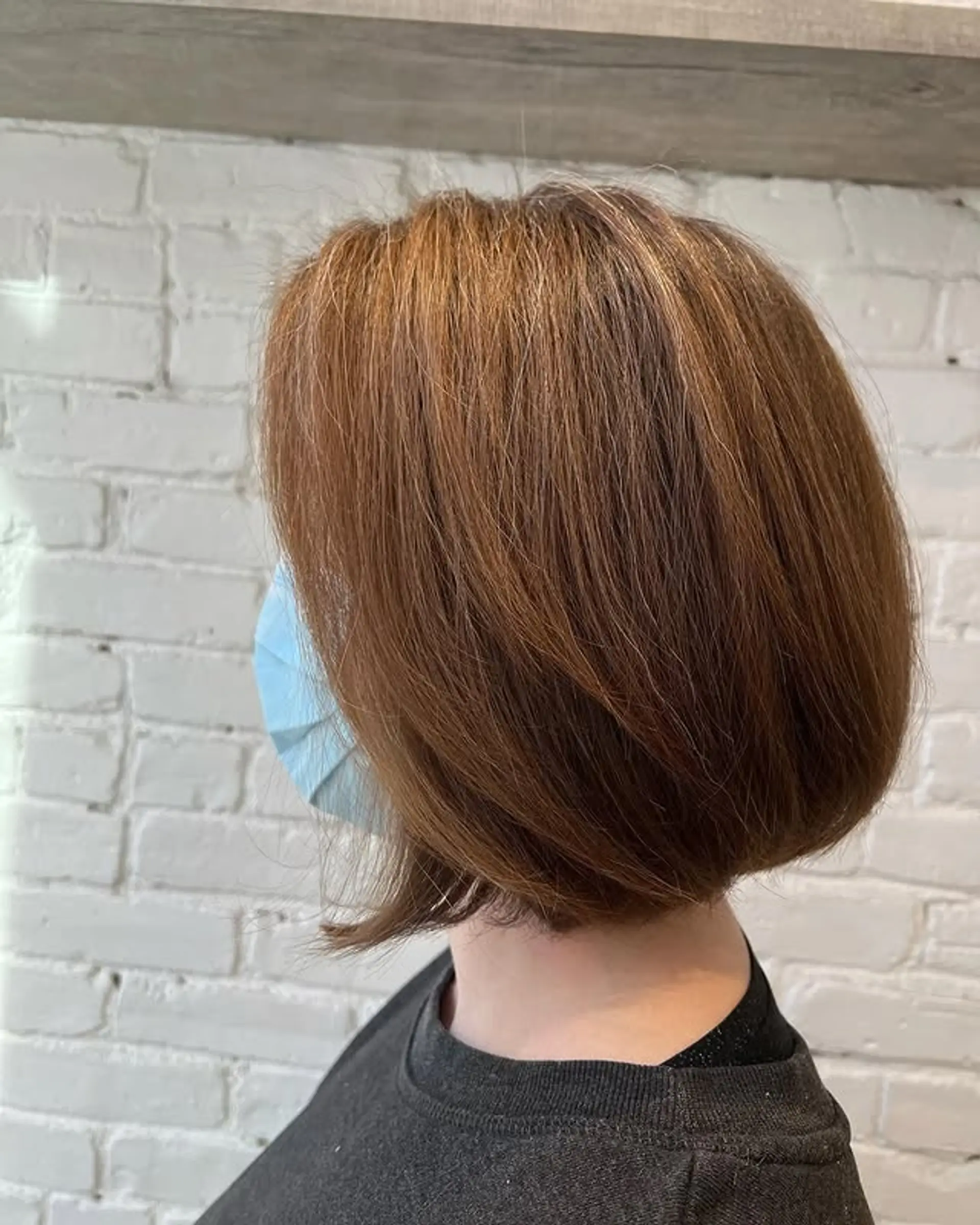 A short, angled bob that is slightly longer in the front and shorter in the back. The hair is styled straight with a smooth finish. 1
