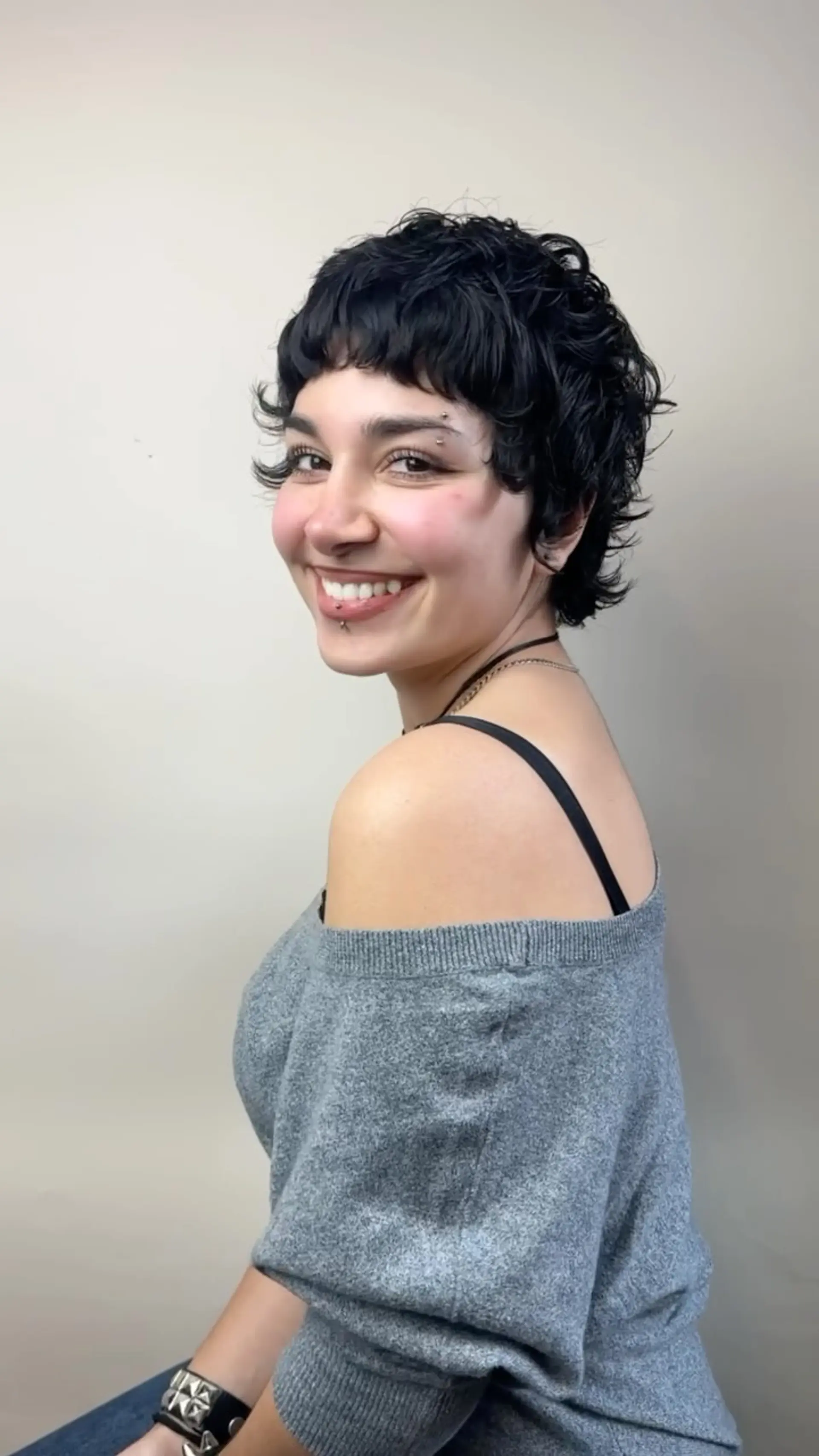 A textured bixie haircut with choppy micro bangs, piecey layers, and natural soft waves. 1