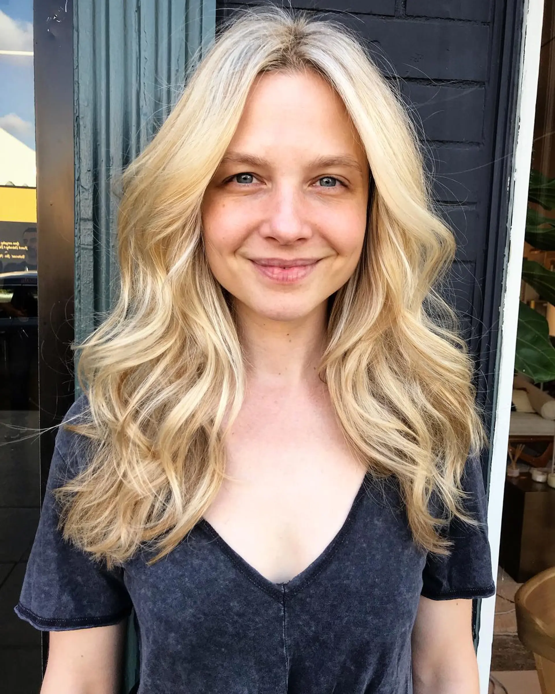 Long, bright blonde hair styled in soft, flowing beach waves with a center part. 1