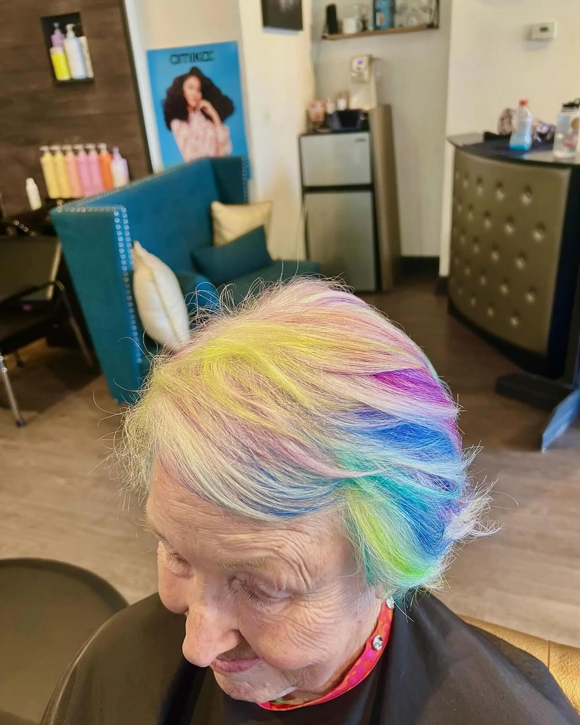 A short, textured haircut styled with a vibrant multicolored palette featuring yellow, pink, purple, blue, and lime green tones. 1