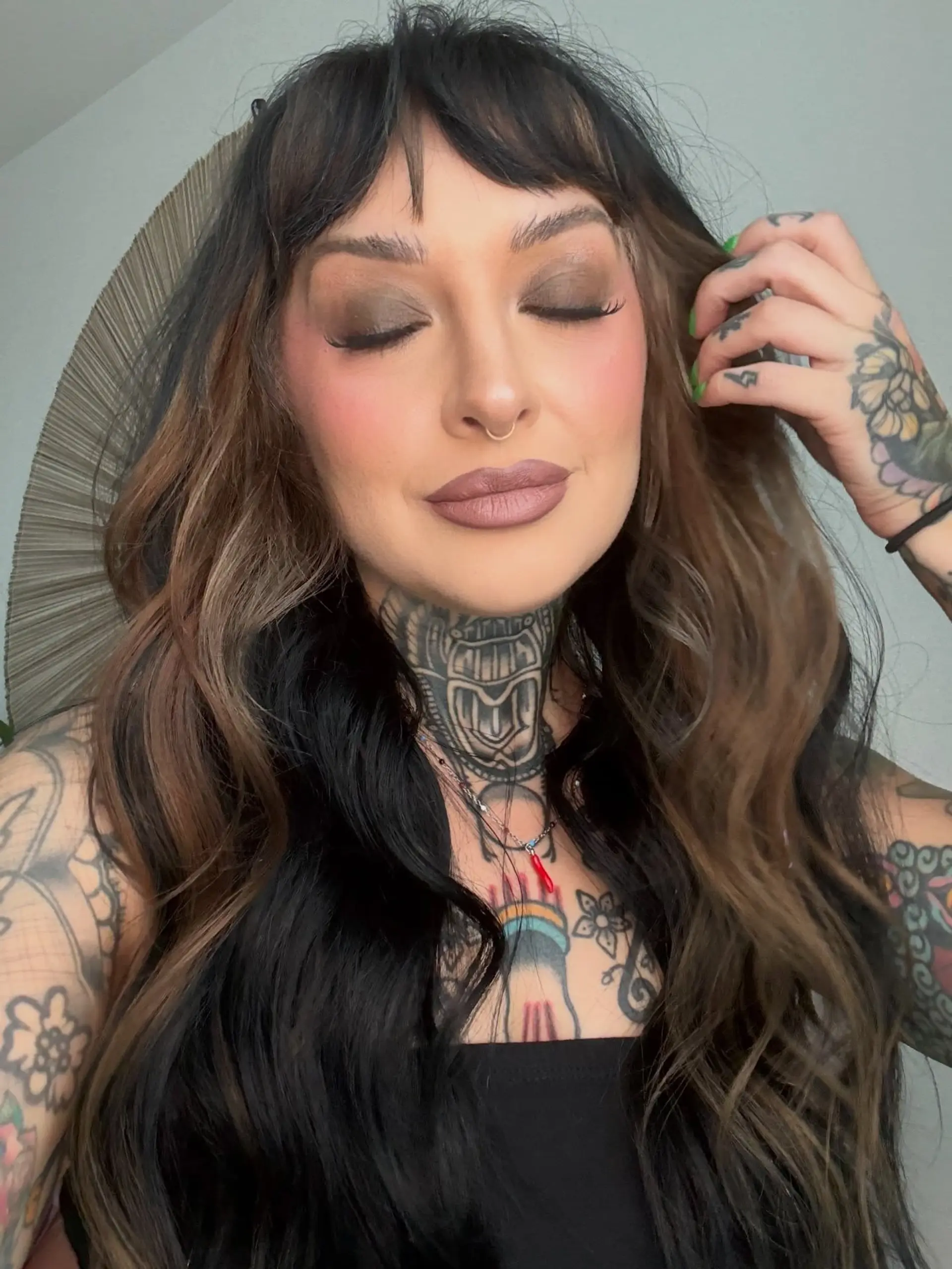 Long cascading waves featuring deep black base tones complemented by warm brown peek-a-boo panels underneath, framed with wispy textured bangs. 1