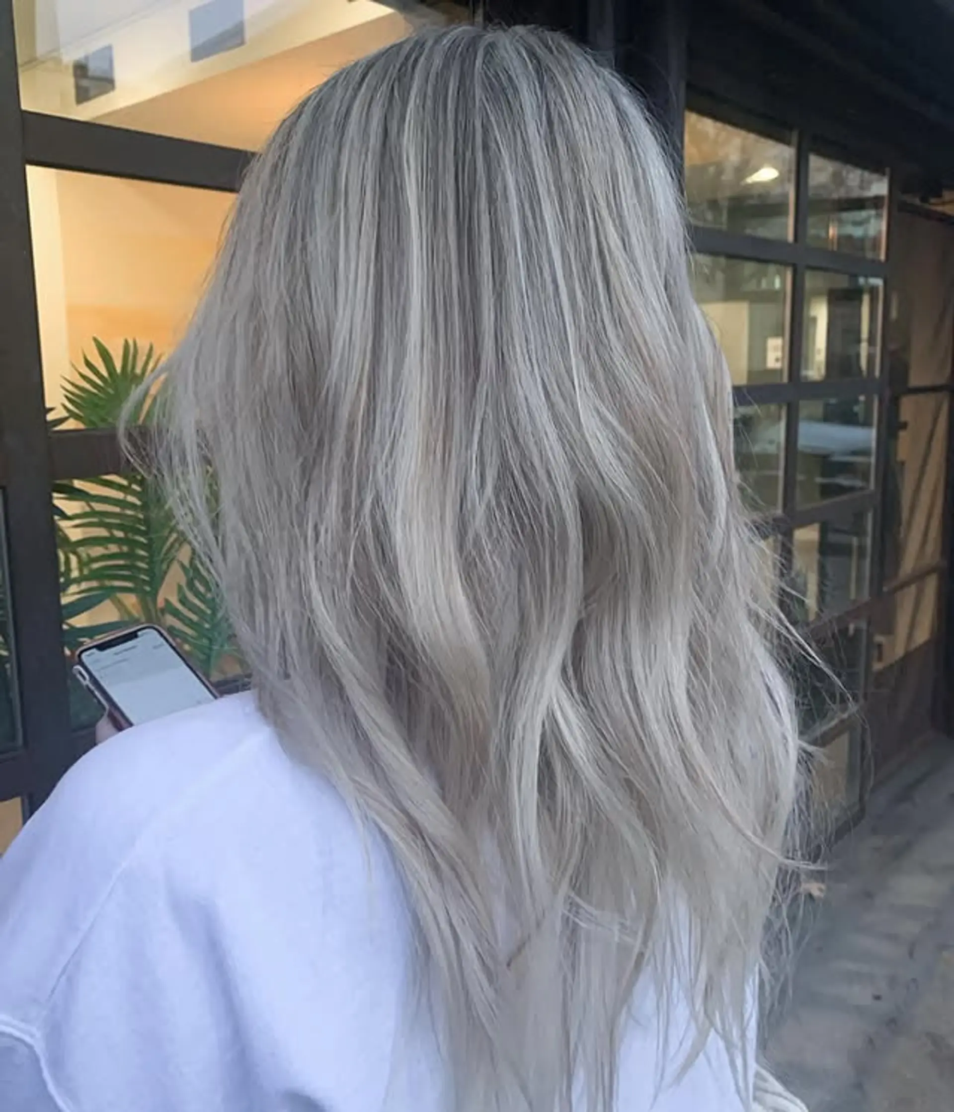 Long, straight hair with a trendy icy blonde balayage featuring platinum blonde and silver hues. 1