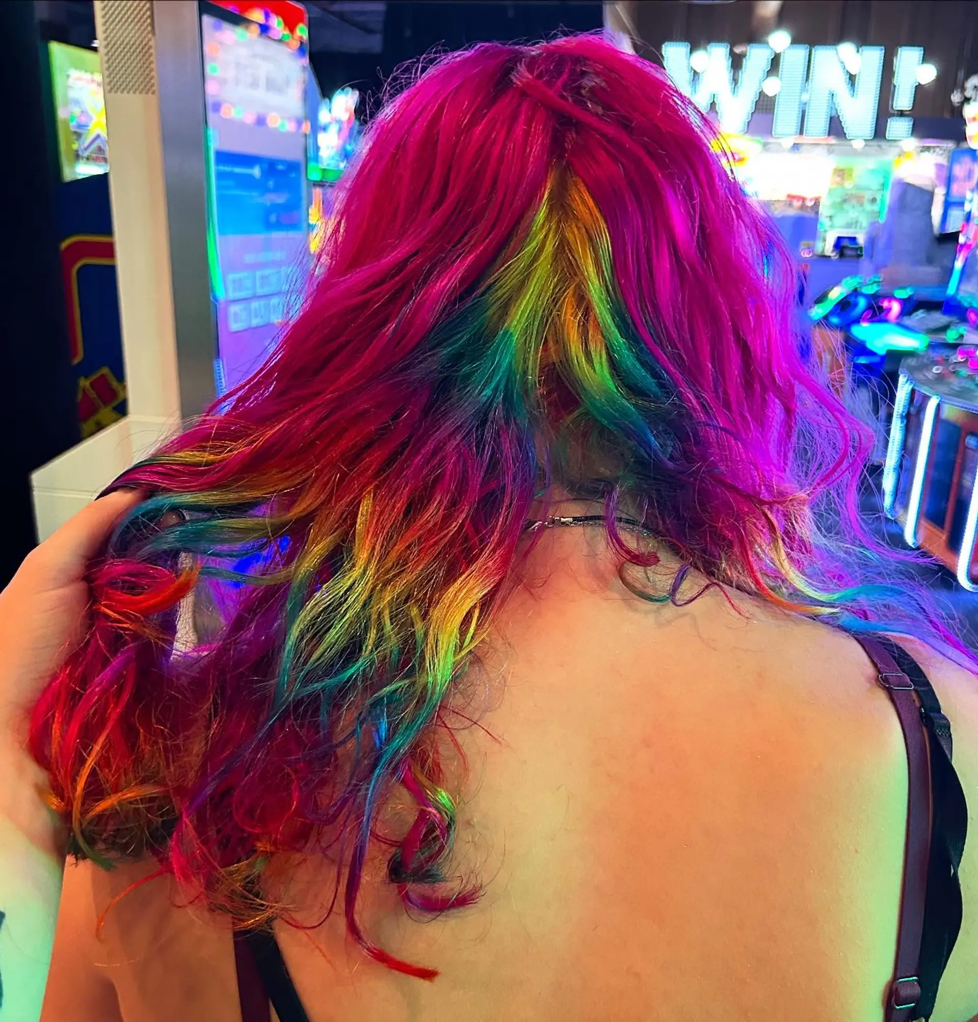 Vibrant hot pink wavy hair featuring a concealed rainbow underlayer revealed beneath. 1