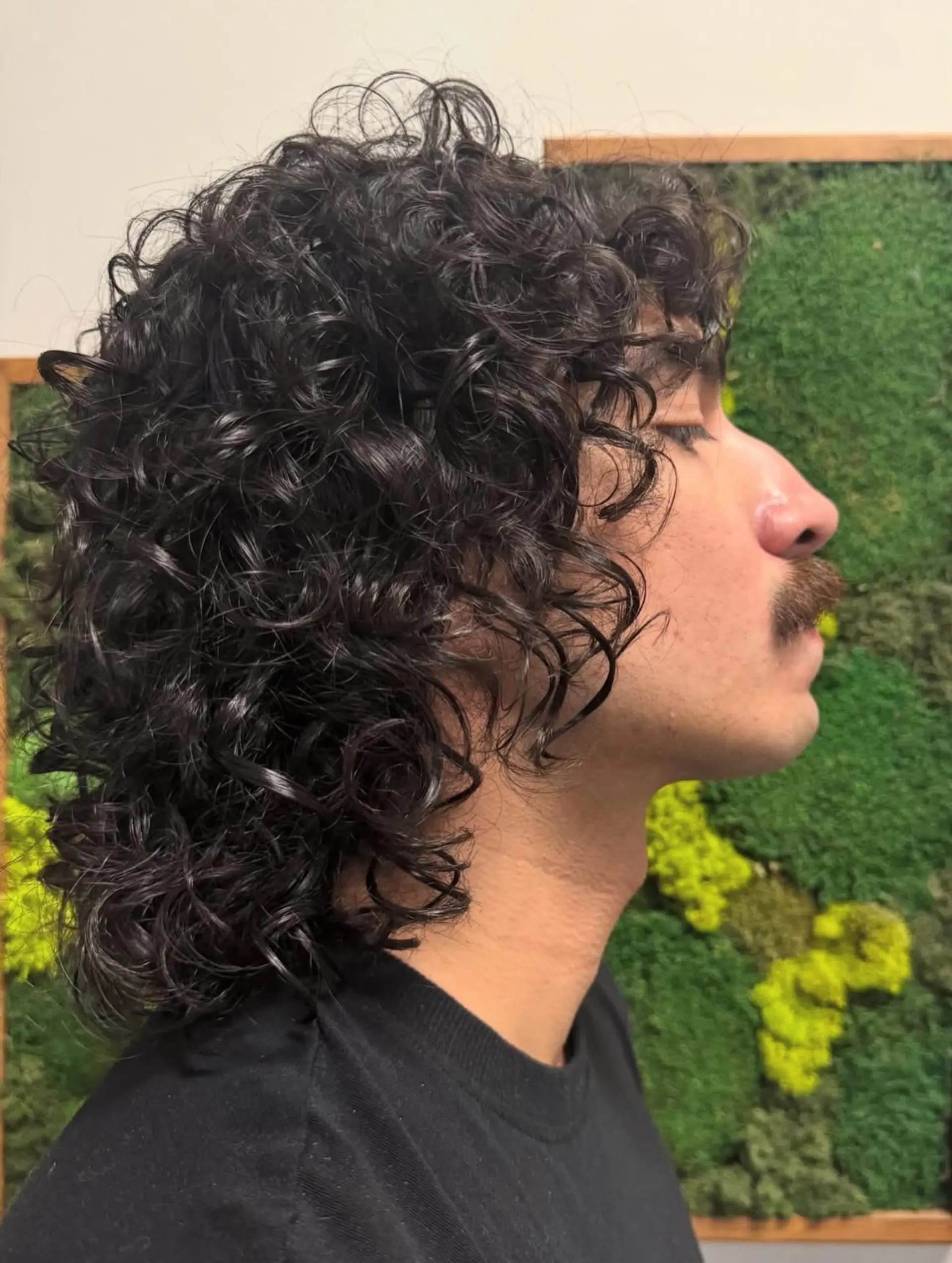 A voluminous curly perm styled into a textured shag mullet with glossy, defined curls. 1
