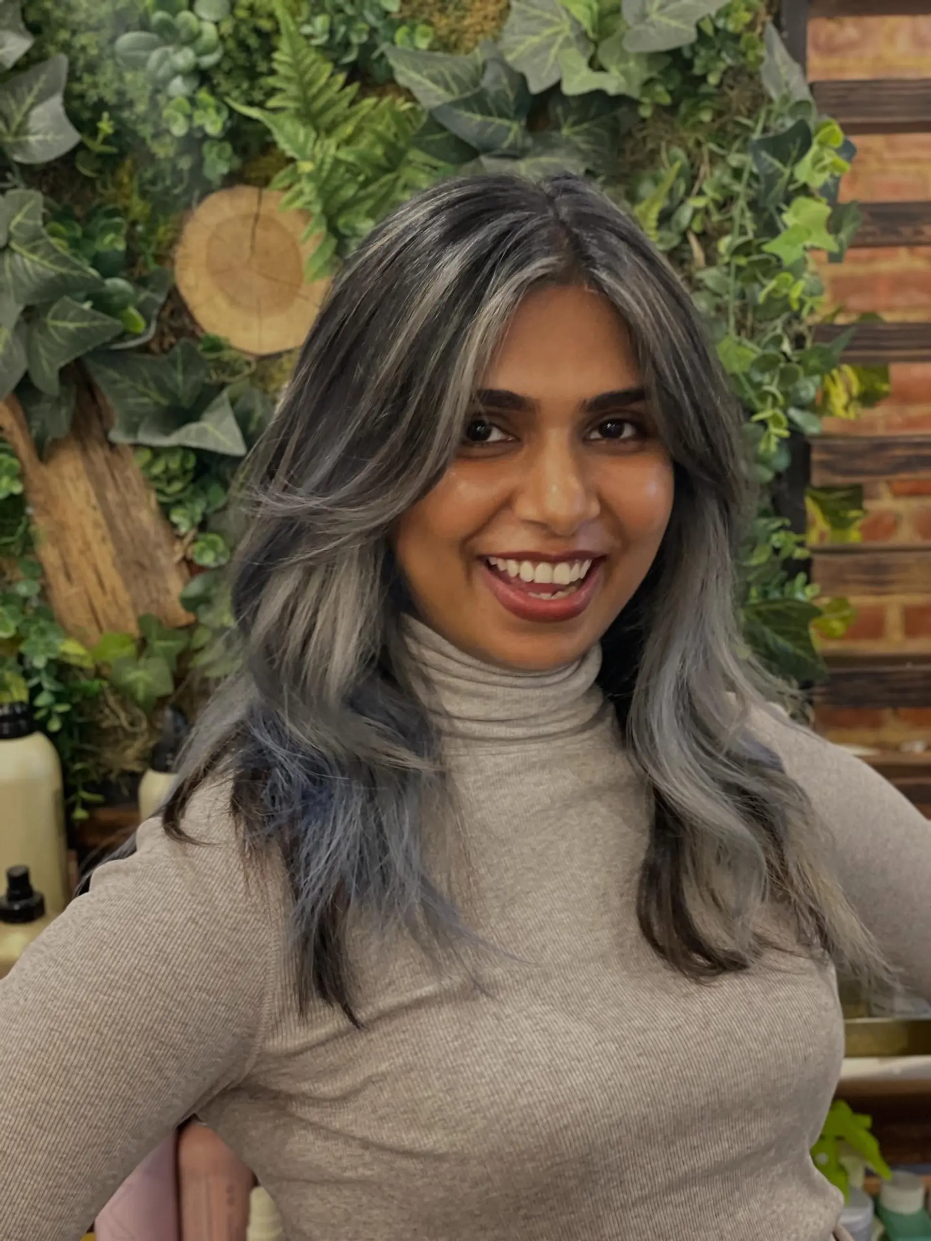 Medium-length layered cut styled with curtain framing and soft waves, featuring dimensional smoky silver and cool ash grey highlights. 1