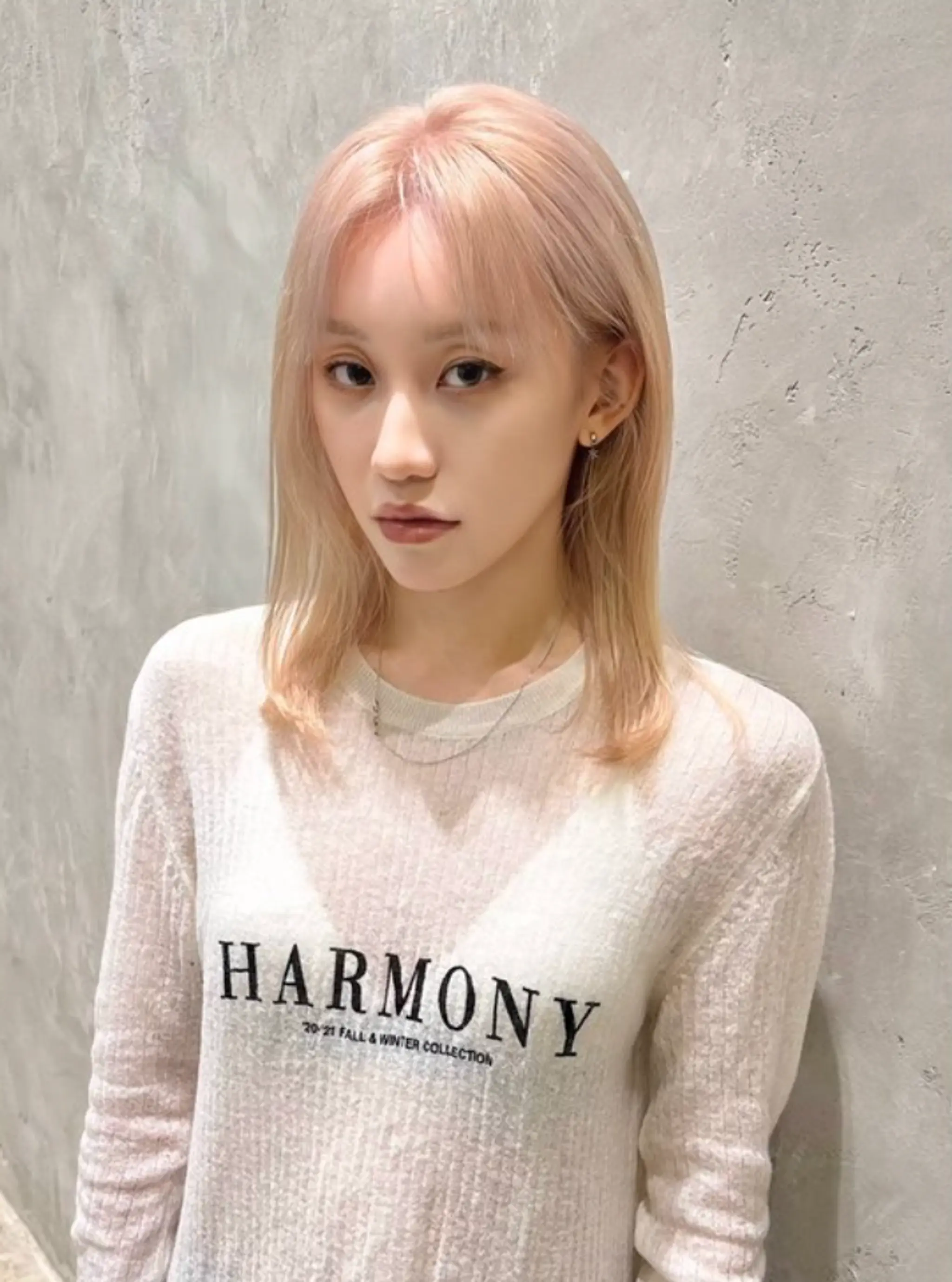 Soft platinum blonde waves flow from a middle part, with medium-length hair gently framing the face. The slight waves add texture and movement, enhancing the silky and smooth appearance. The cut features subtle layers for a natural and understated look.
(NonstopStyle: by Hiro)