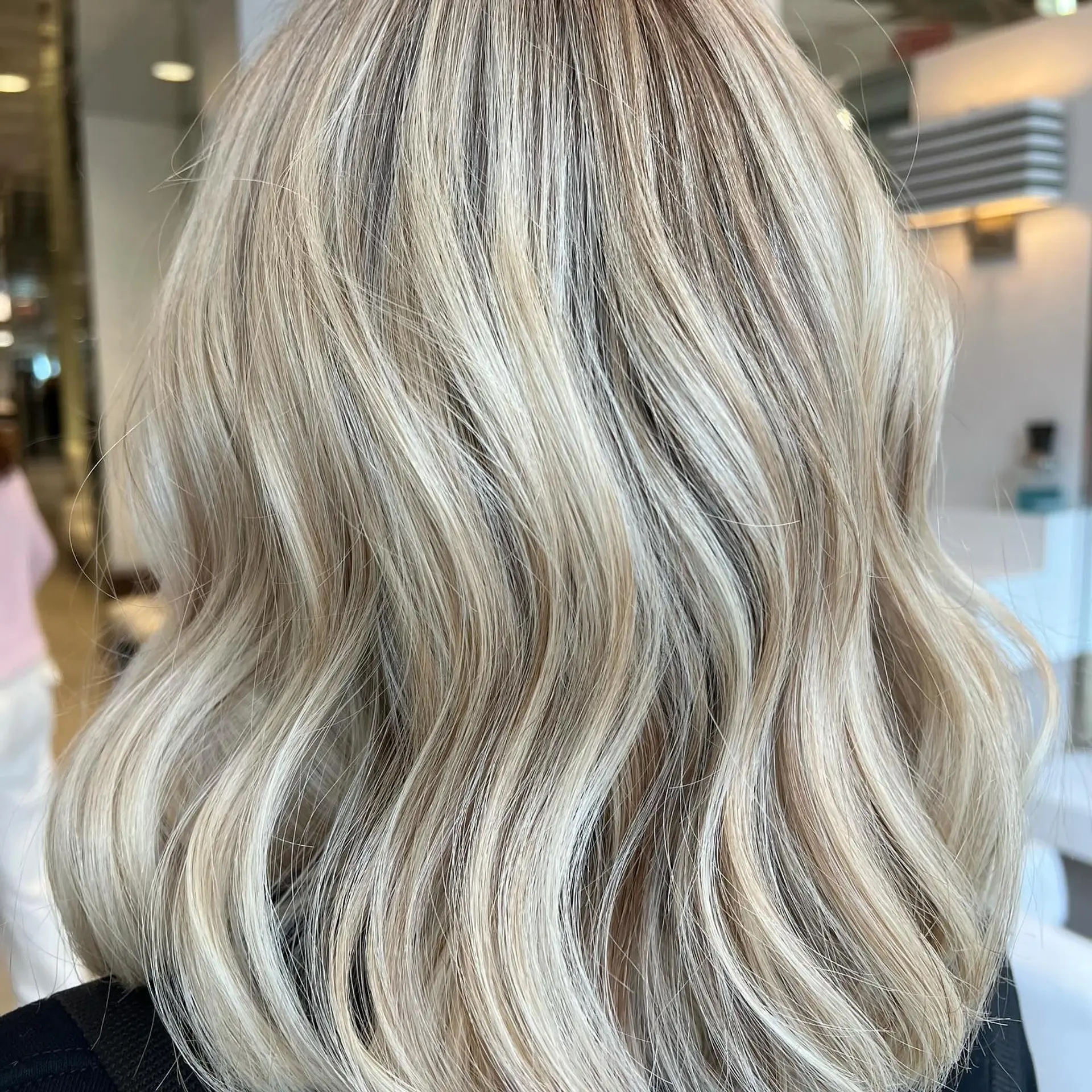 Medium-length blonde lob styled in soft, defined waves with dimensional highlights. 1