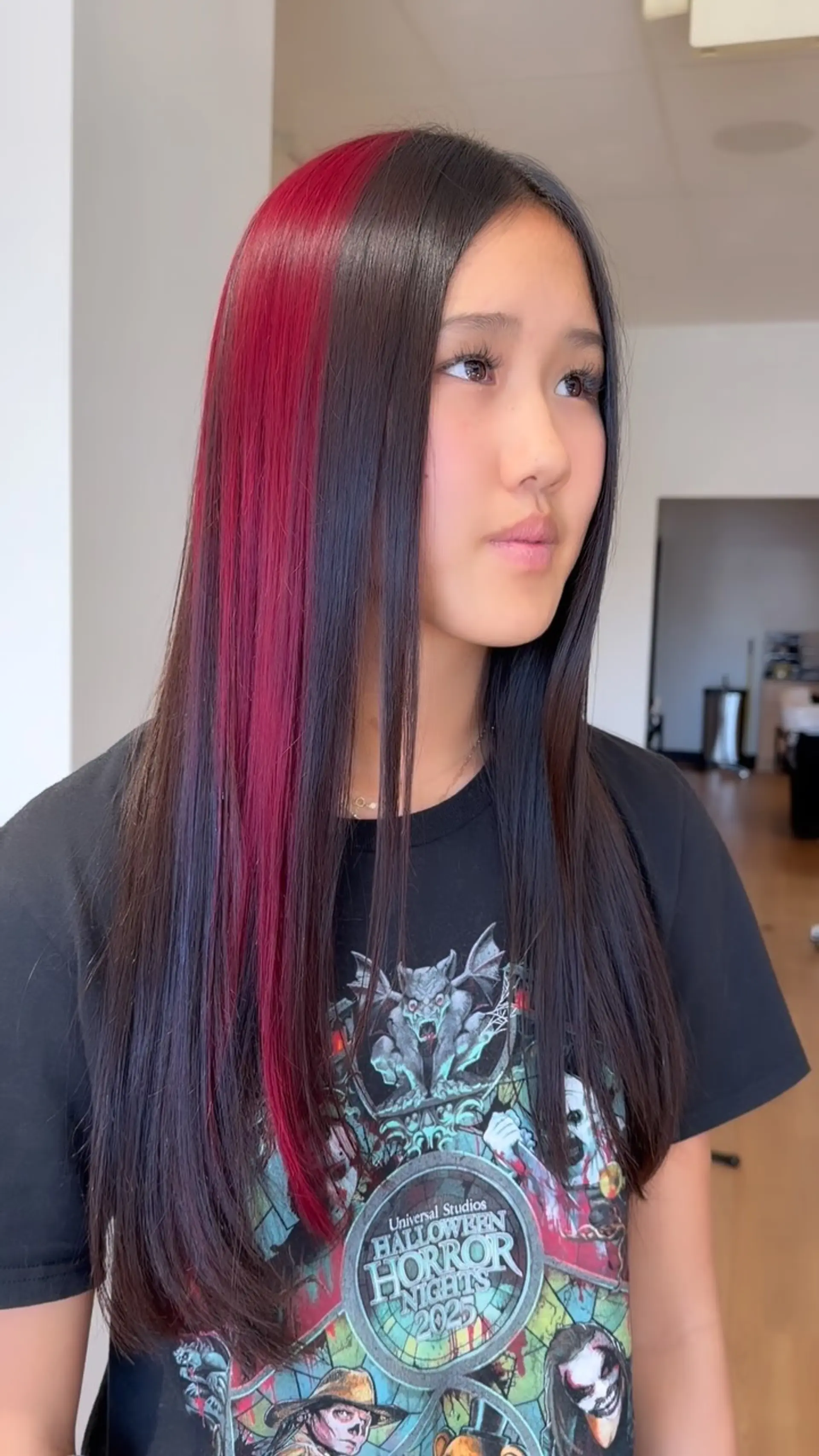 Long, glossy straight dark hair featuring a vibrant crimson-red color block section along the side. 1