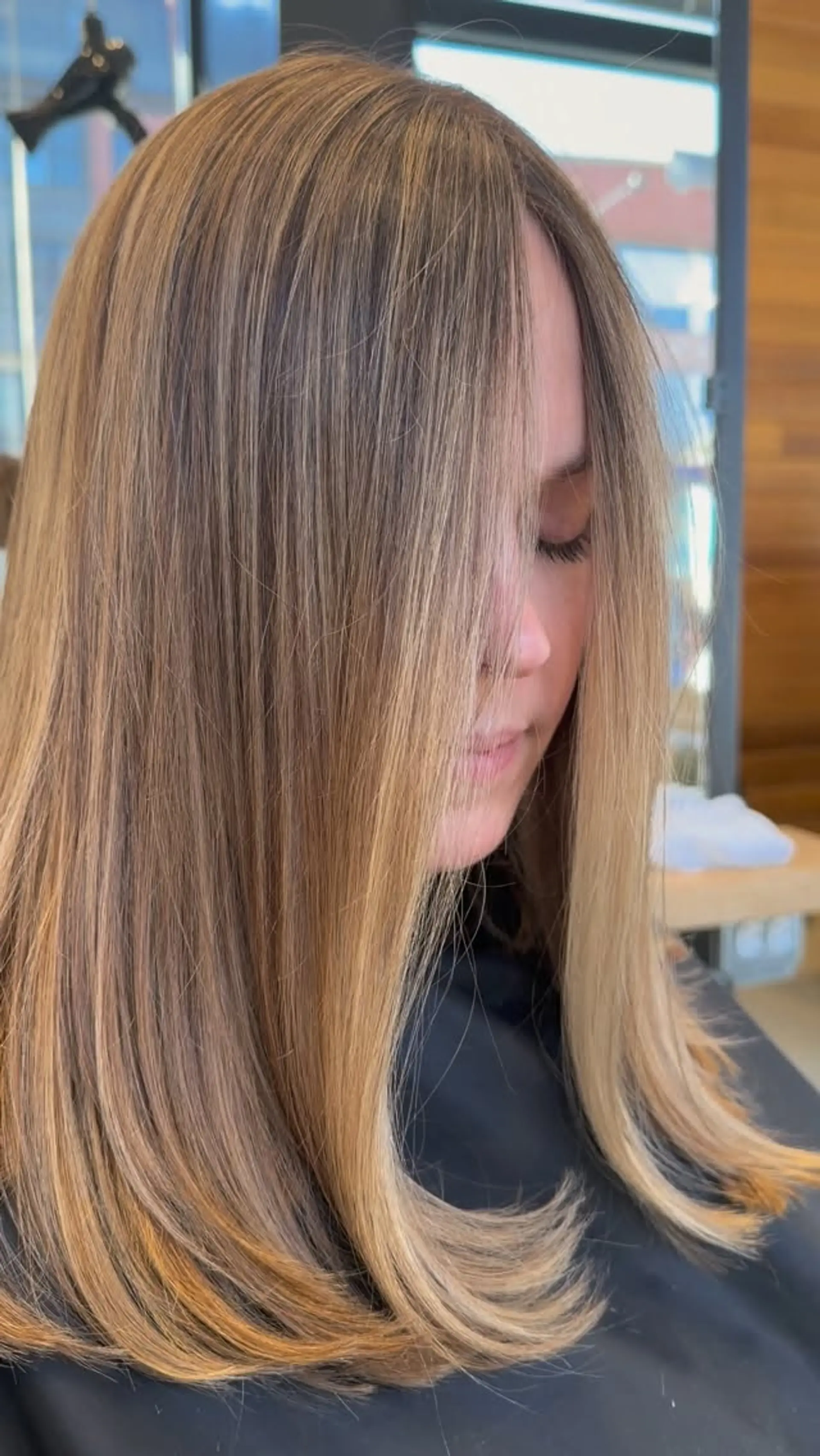 Straight, smooth medium-length hair with soft flipped ends and blended honey blonde highlights. 1