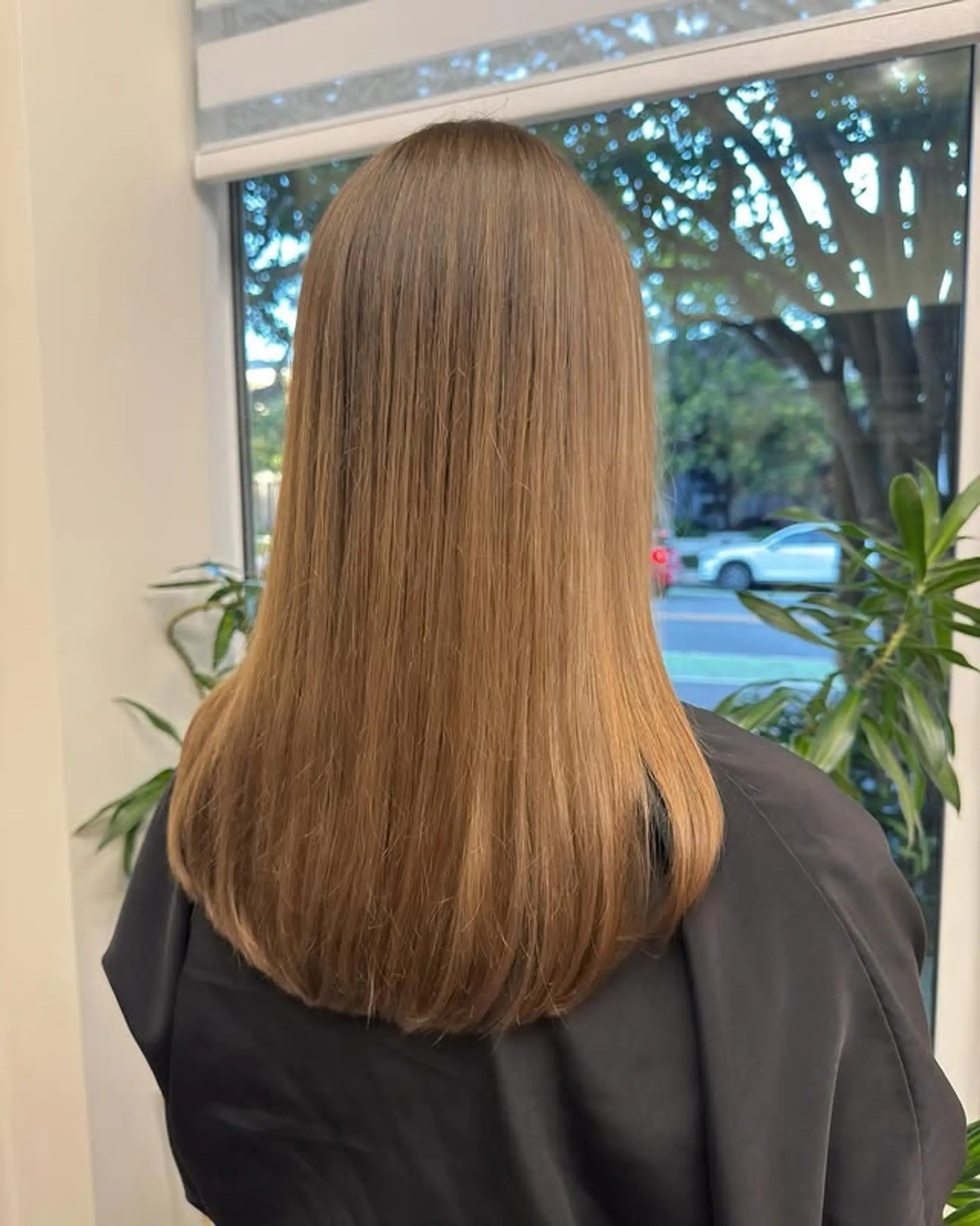 Long layered straight hairstyle with a honey blonde color. 1