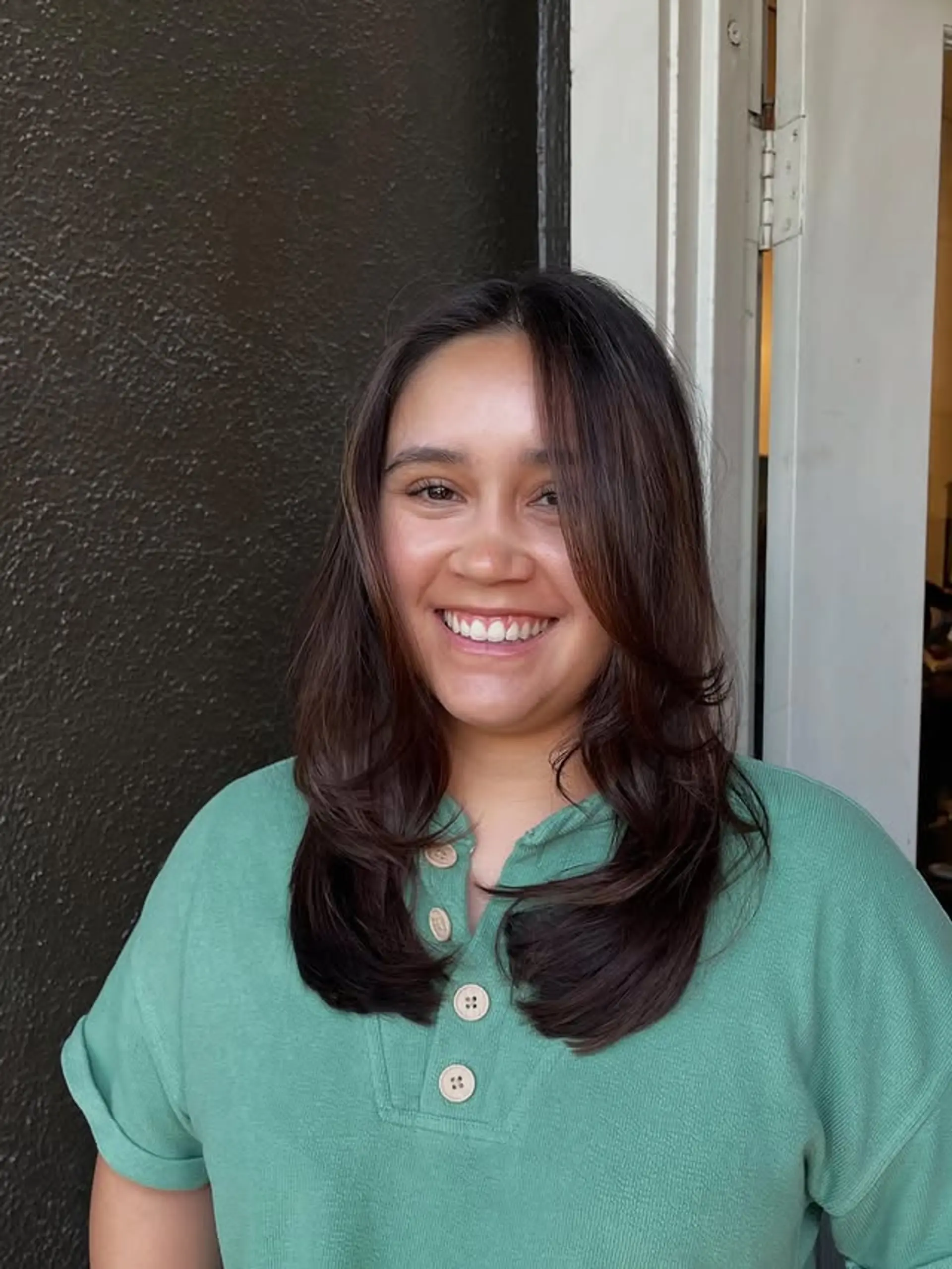 A medium-length layered haircut with face-framing layers. 1