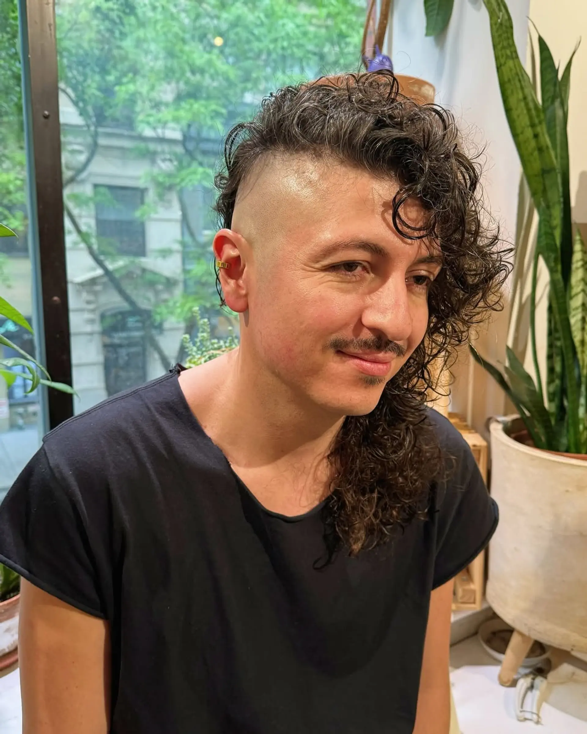 A modern mullet with shaved sides and long, textured curls. 1