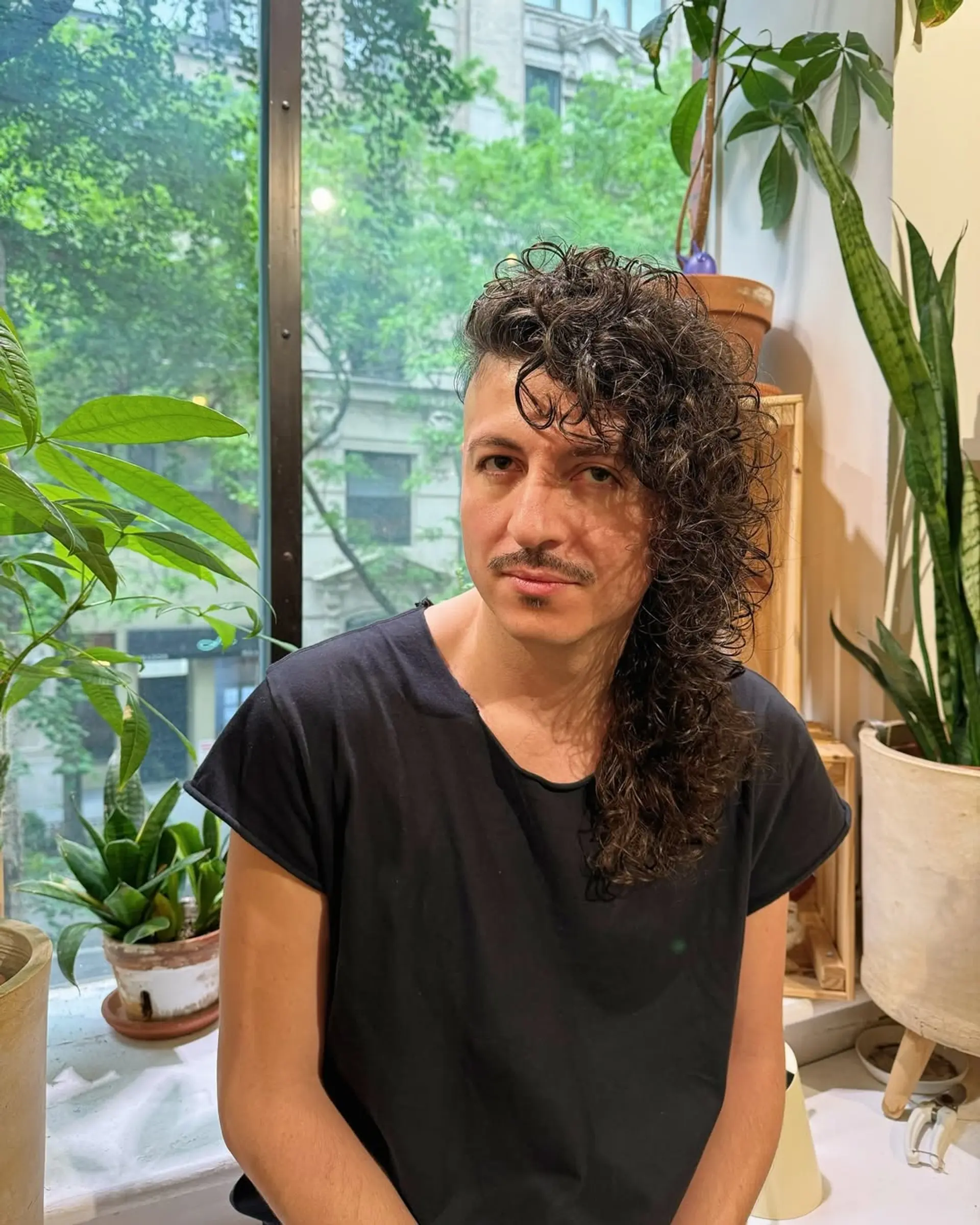 A modern mullet with shaved sides and long, textured curls. 2