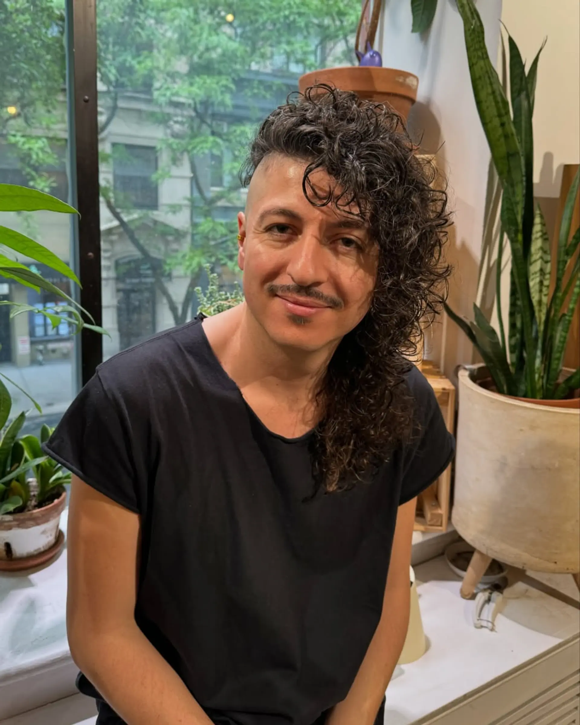 A modern mullet with shaved sides and long, textured curls. 3