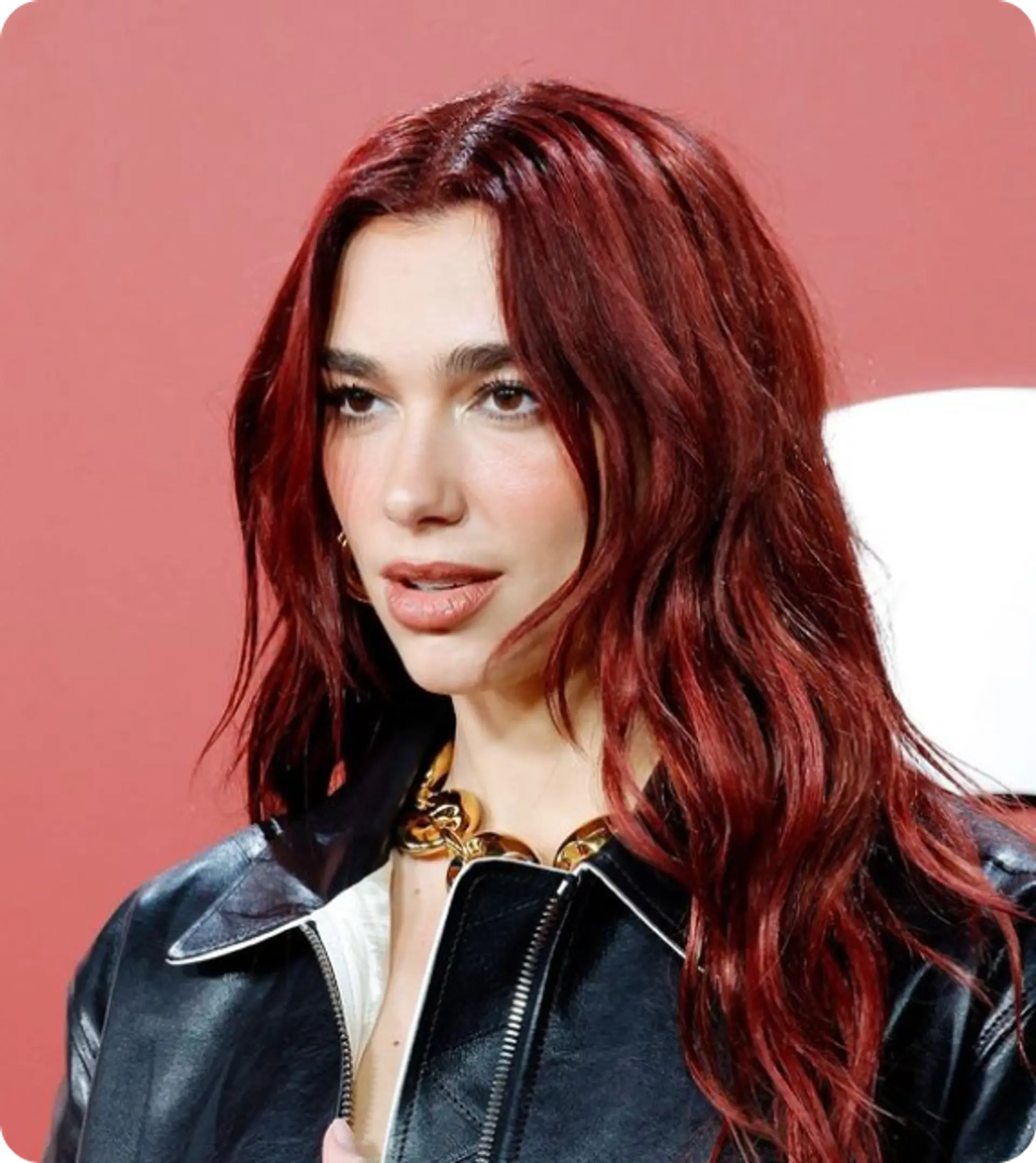 Stunning long wavy hairstyle with vibrant red hair. Center-parted with loose waves cascading down past the shoulders, providing a graceful and voluminous look. The glossy finish enhances the elegance. 1