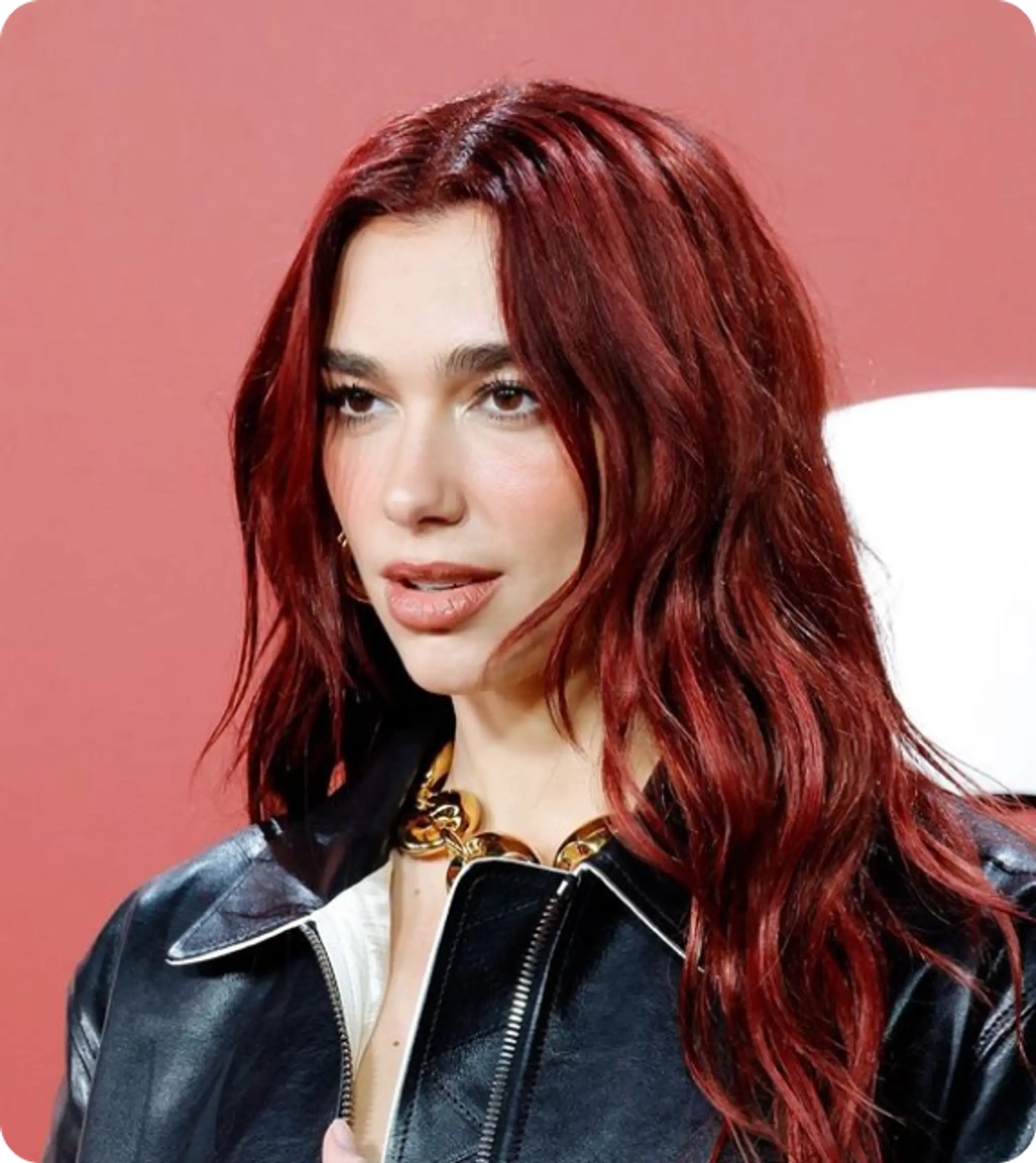 Stunning long wavy hairstyle with vibrant red hair. Center-parted with loose waves cascading down past the shoulders, providing a graceful and voluminous look. The glossy finish enhances the elegance.