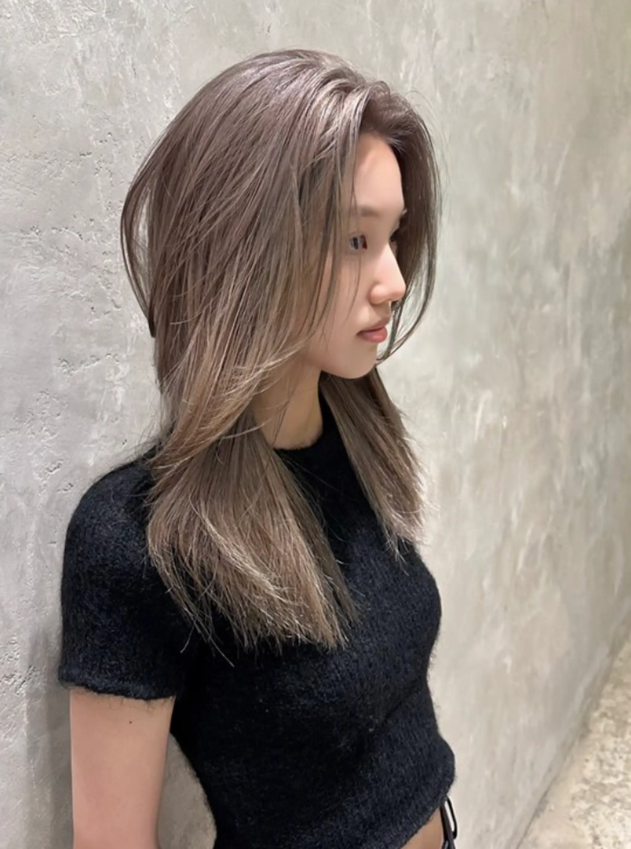 A medium-length layered hairstyle featuring a center parting with a blend of ash blonde and silver highlights. The layers add volume and texture to the straight, sleek appearance.

(NonstopStyle: by Hiro)