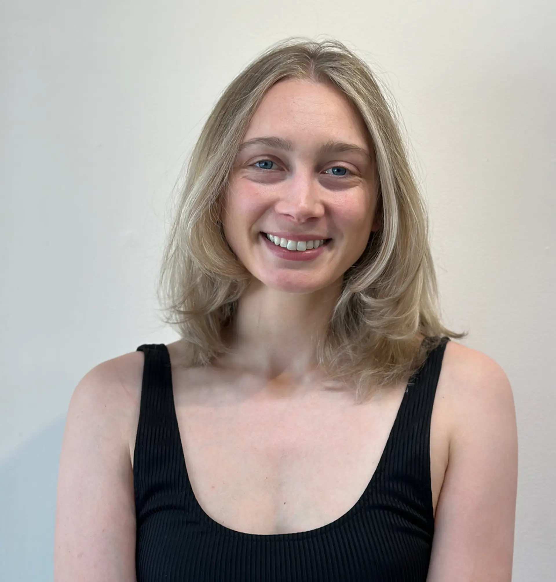 Medium-length light ash blonde hair with subtle layers and soft, natural waves, featuring a middle part and smooth finish. 1