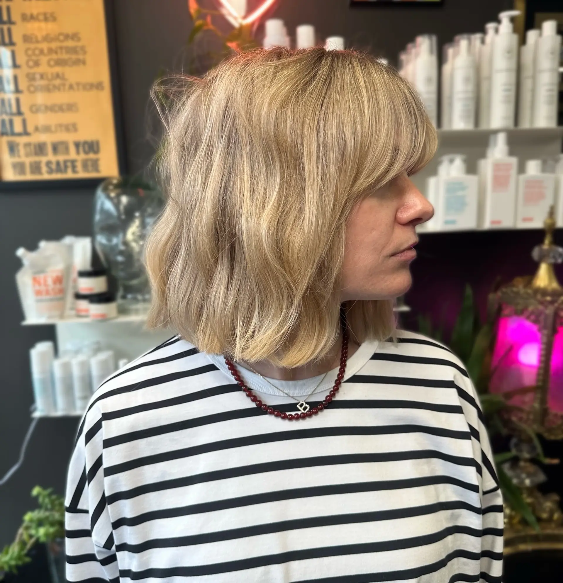 A dimensional blonde mid-length lob styled with subtle, lived-in waves and feathered bangs. 1