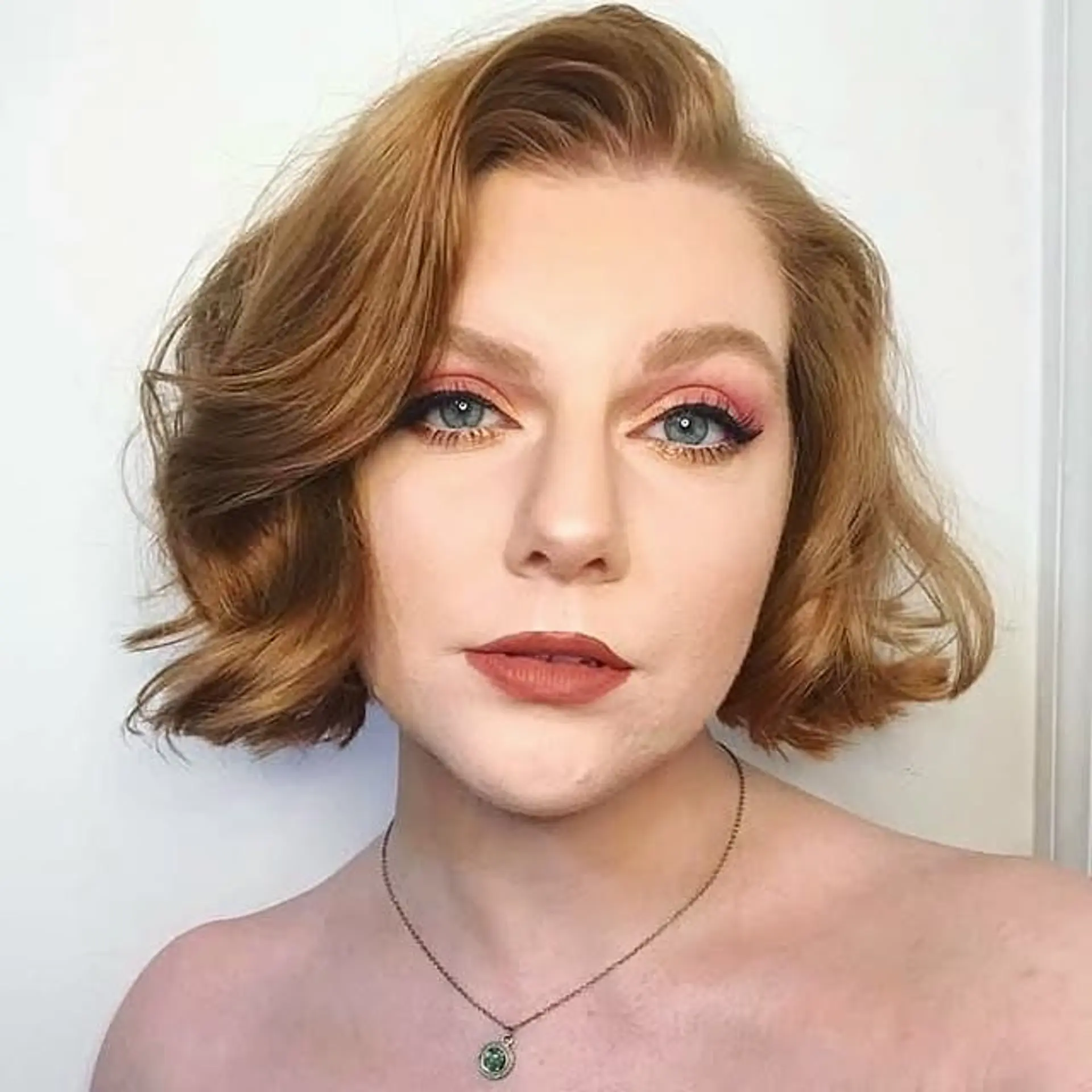 A short, wavy bob styled with deep waves and a side part, reminiscent of old Hollywood glamour. 1