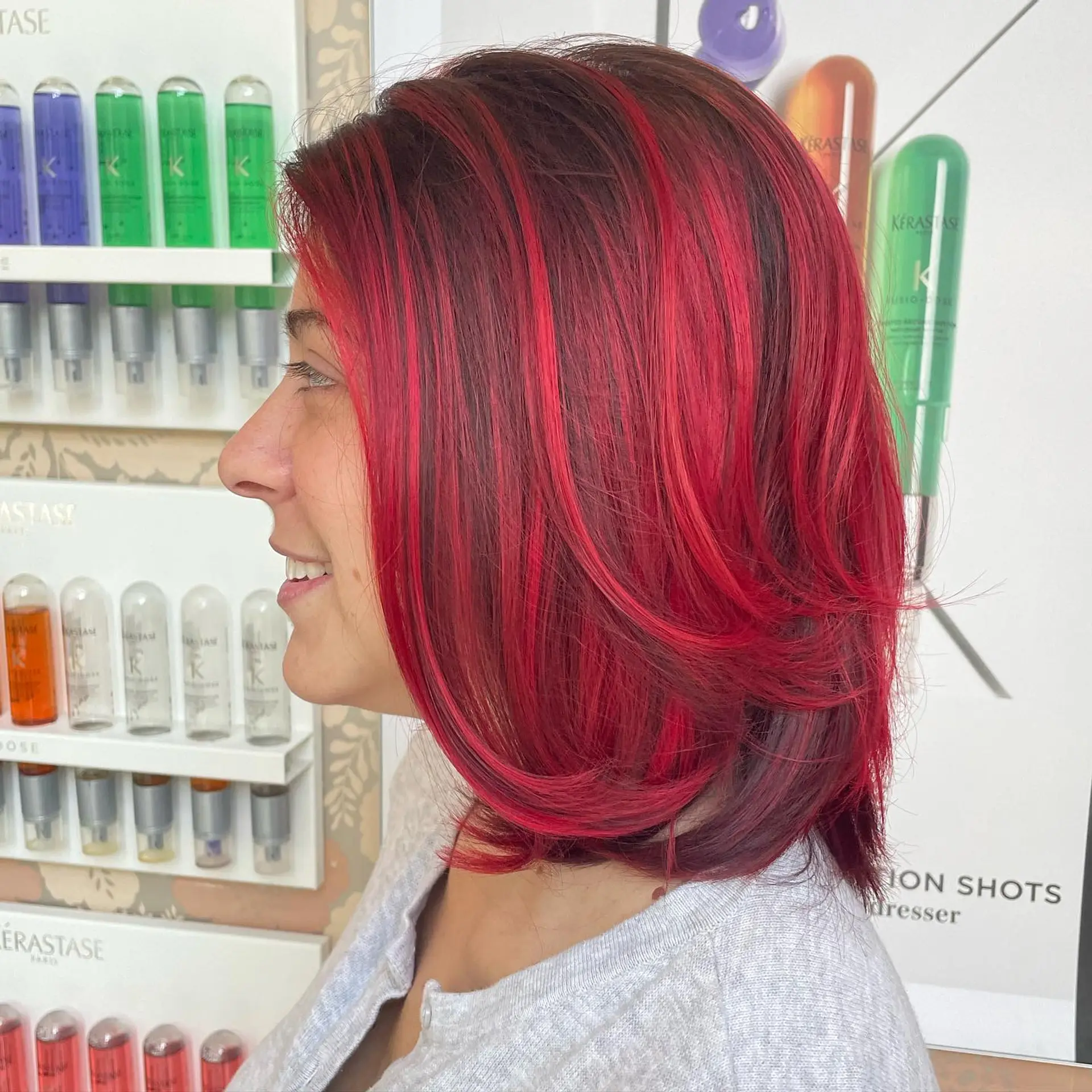 A medium-length layered lob dyed in striking crimson and deep burgundy tones with smoothly styled curved ends. 1