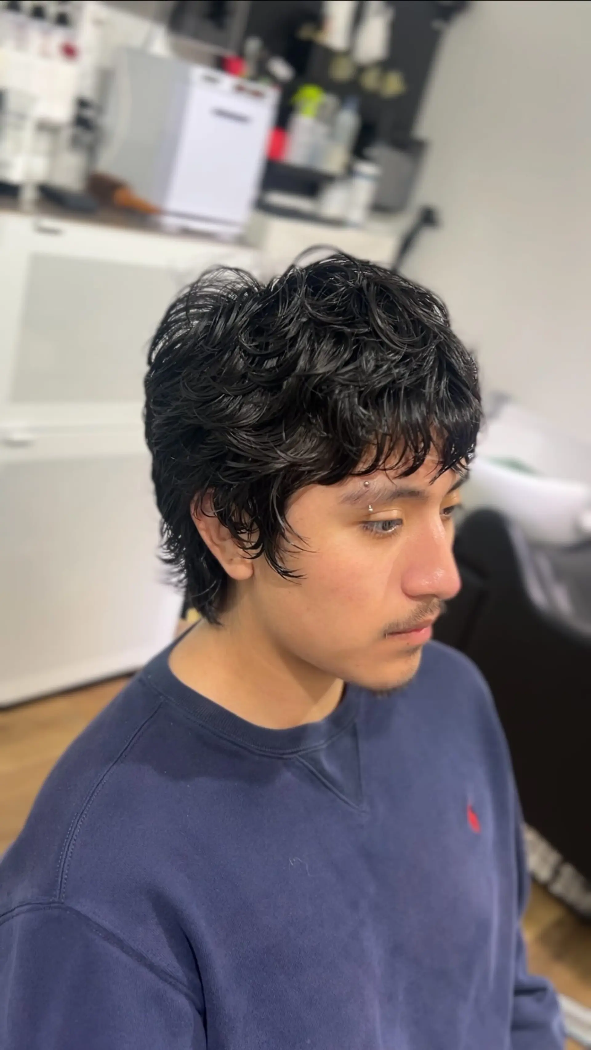 A short, layered cut enhanced with a soft wave perm, styled with natural texture and forward-swept wavy fringe. 1