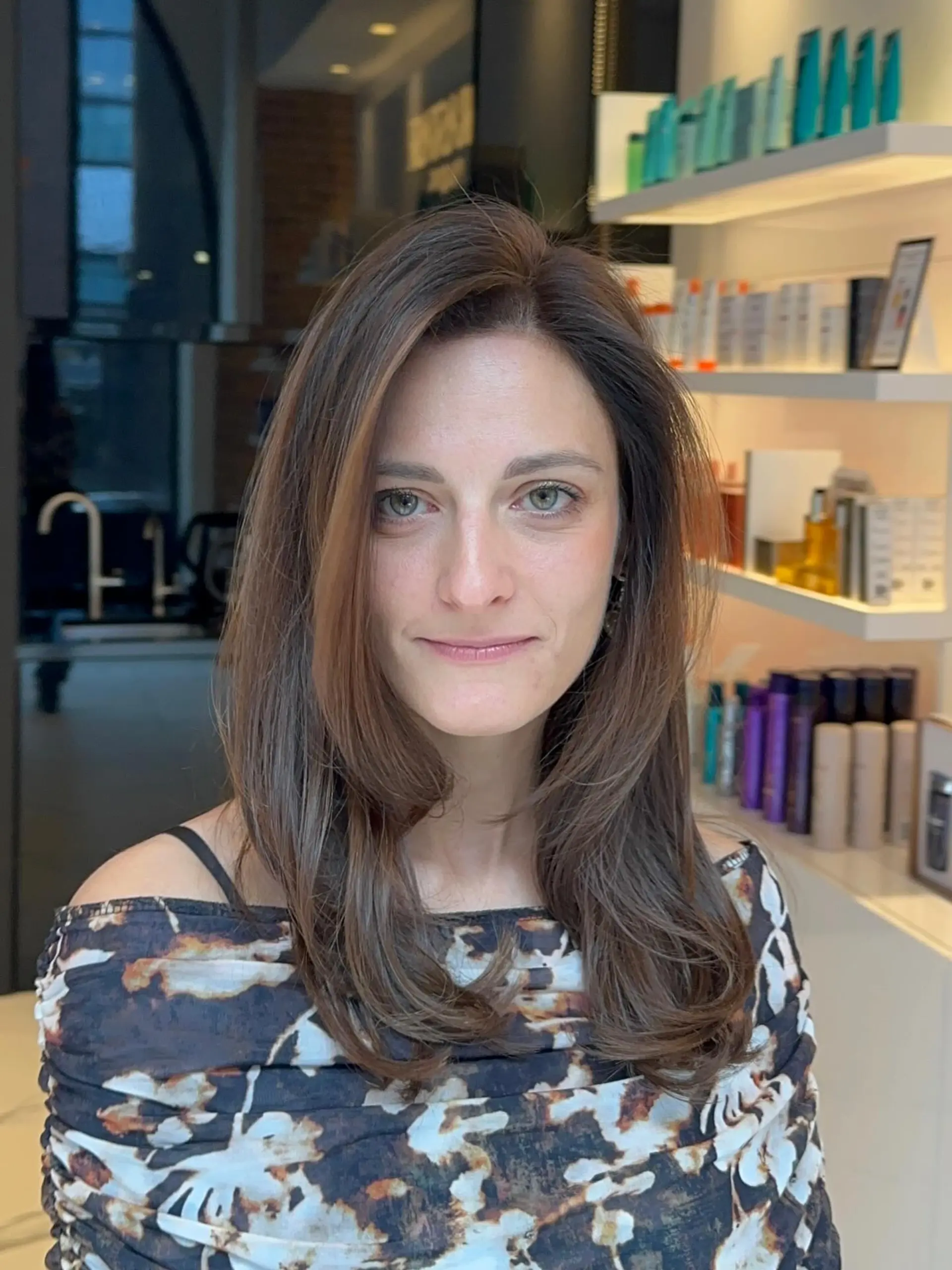 Medium-length glossy brunette hair with gentle face-framing layers and soft, curled under ends. 1