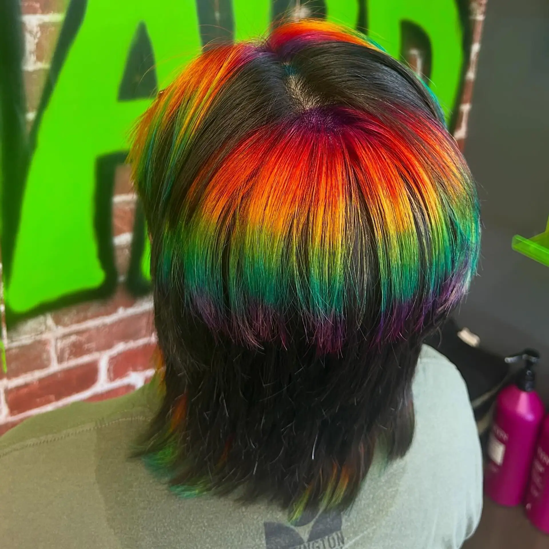 Straight medium layered mullet with a vivid horizontal rainbow prism highlight band over dark hair. 1