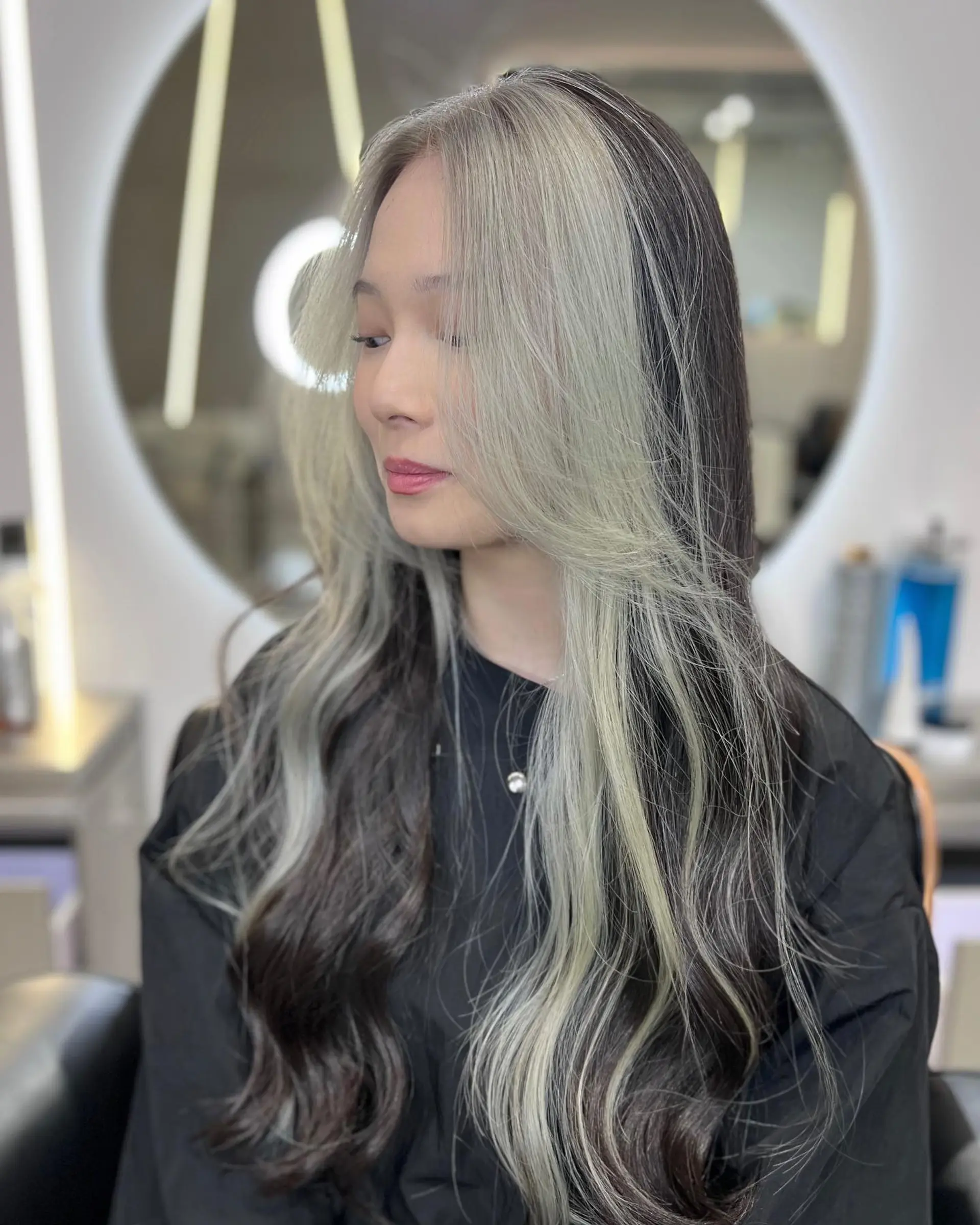 Long wavy hair with face-framing layers and money piece highlights. 3