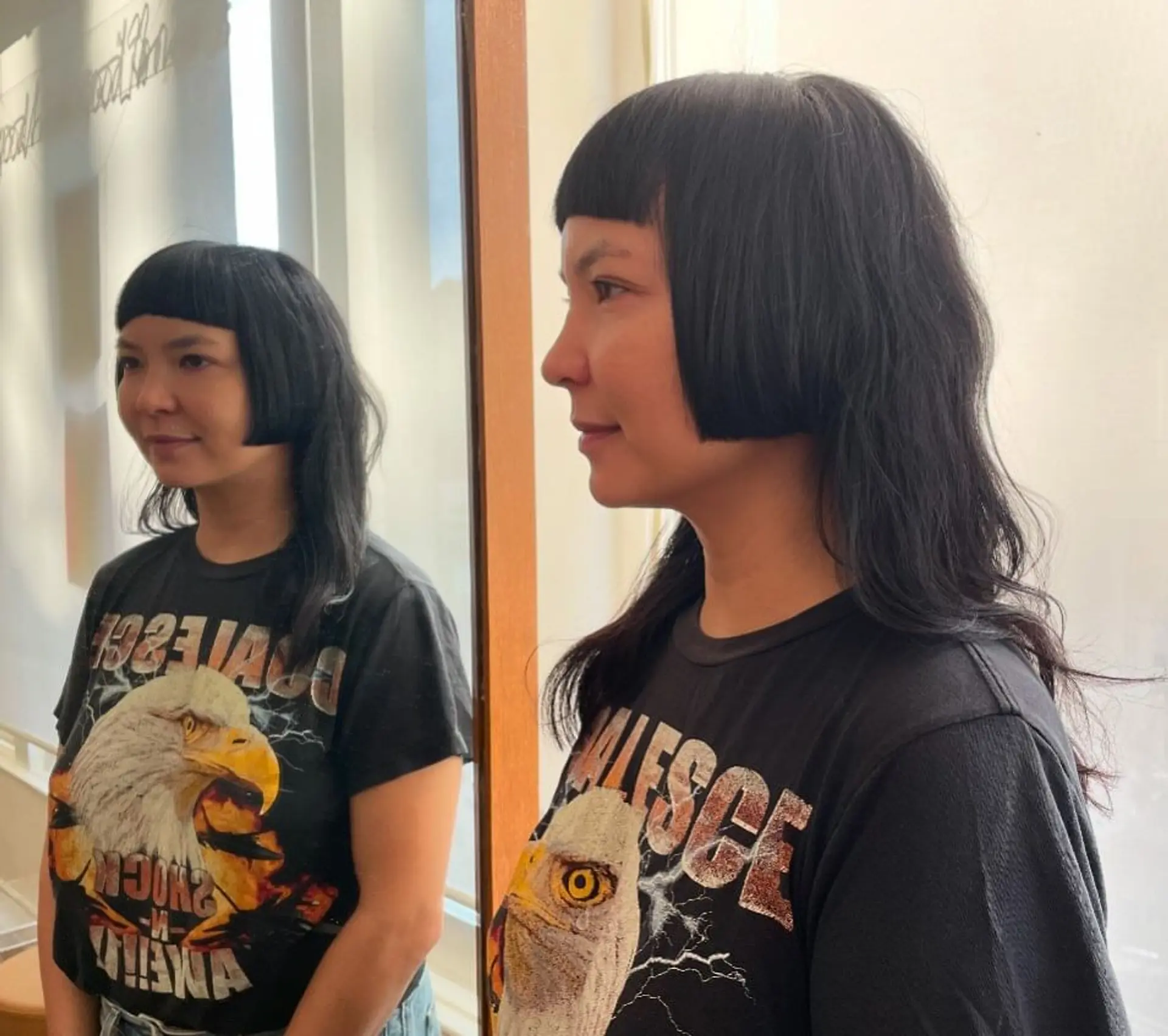 An asymmetrical bob with blunt bangs and layered wavy texture, creating a bold and edgy look. 1