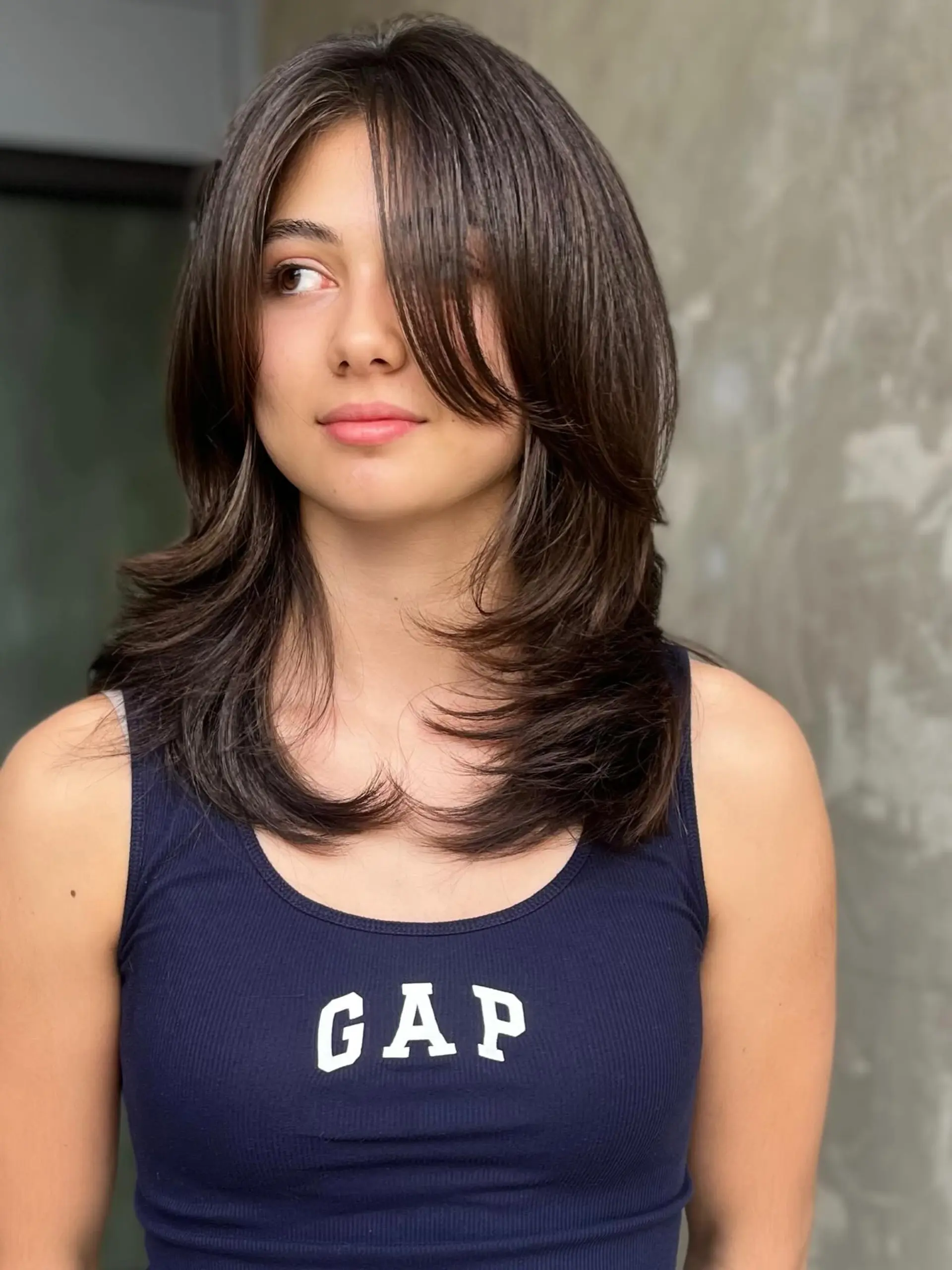 Medium-length layered shag haircut styled with voluminous face-framing fringe and feathered ends. 1