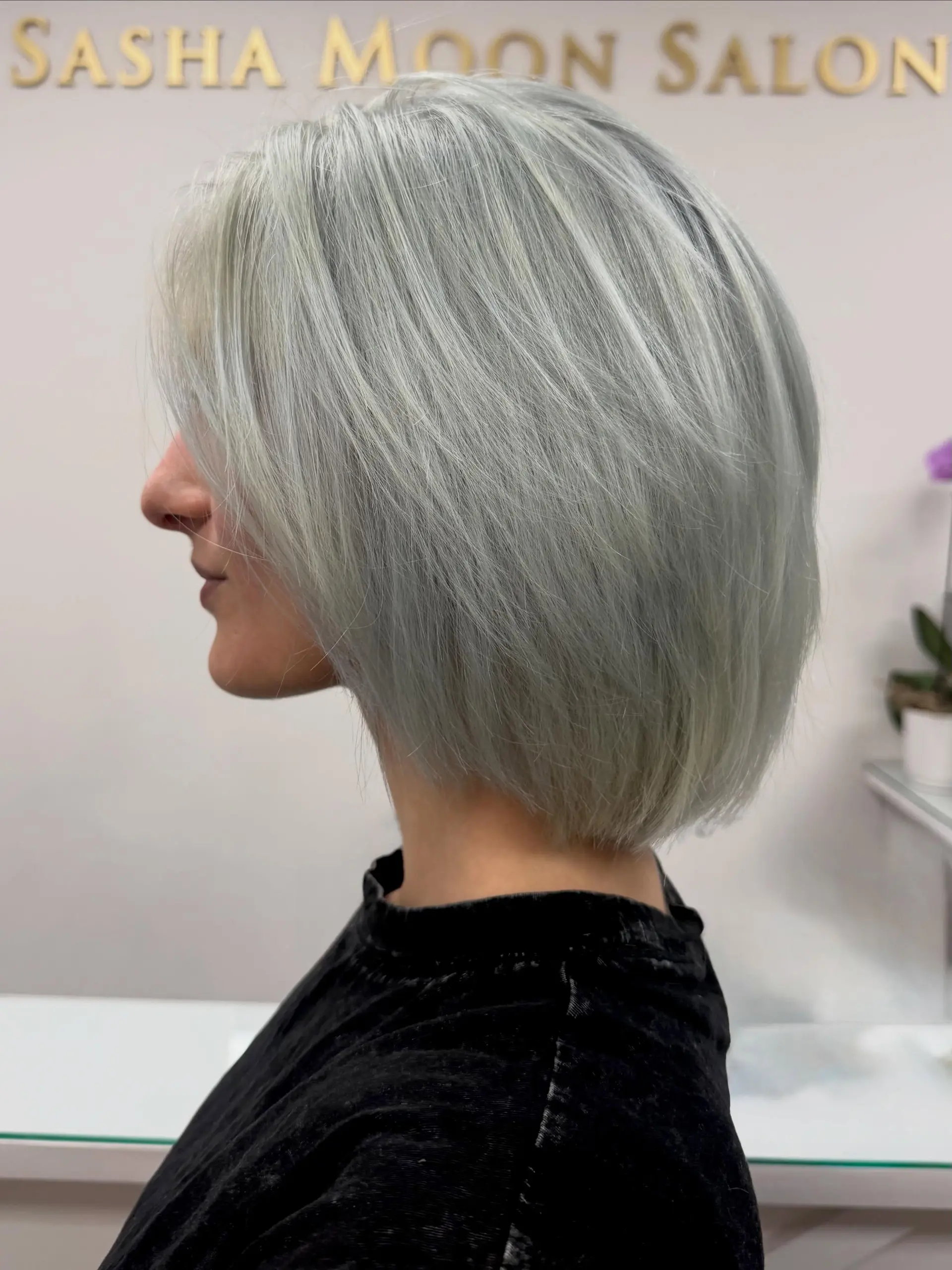 A sleek, chin-length bob featuring shattered layers and finished in a cool, icy blue steel platinum blonde shade. 1