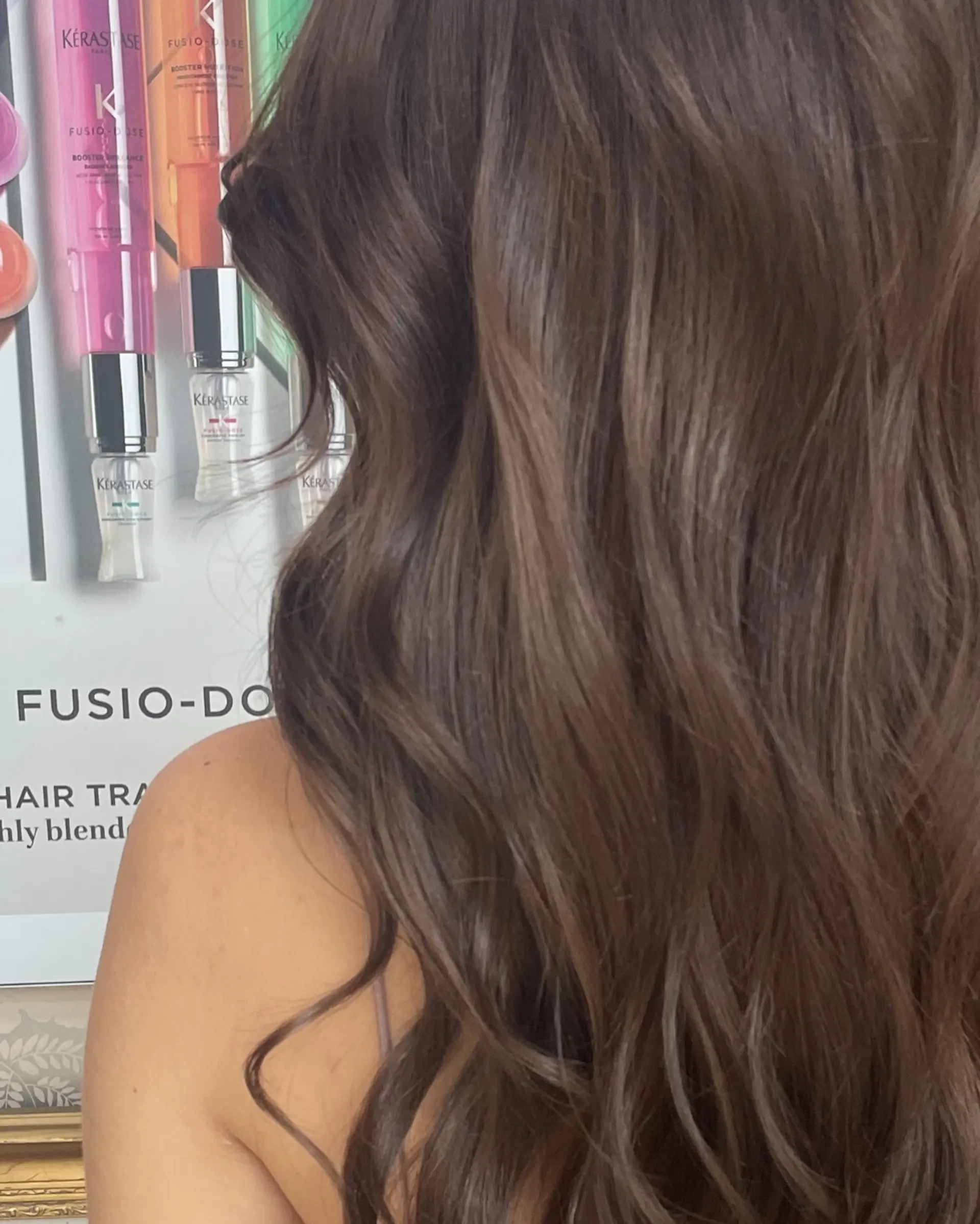 Rich medium brown hair styled with soft, cascading waves that show healthy shine and texture. 1