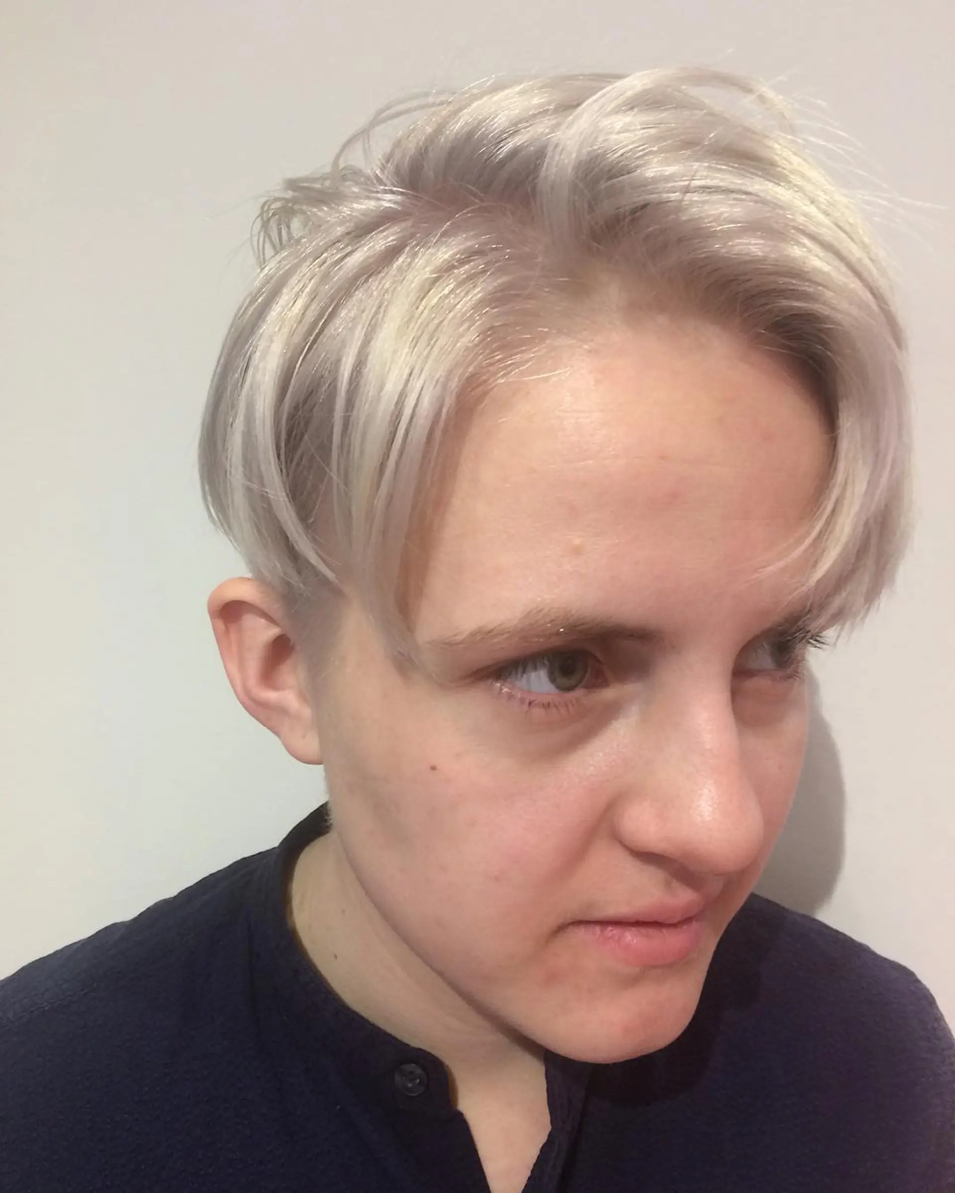 A short, platinum blonde pixie cut with an undercut. 1