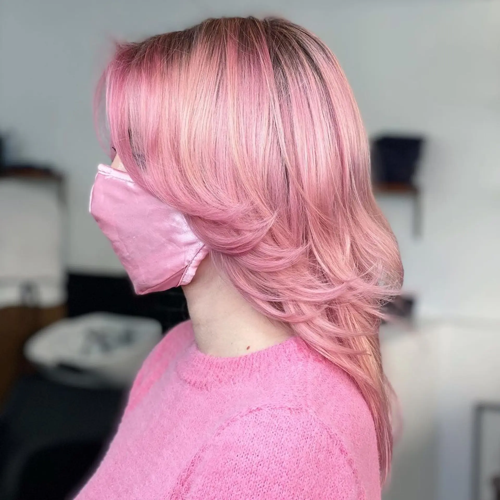 A medium-length, layered hairstyle with soft waves. The hair is colored pastel pink, creating a playful and stylish look. 2
