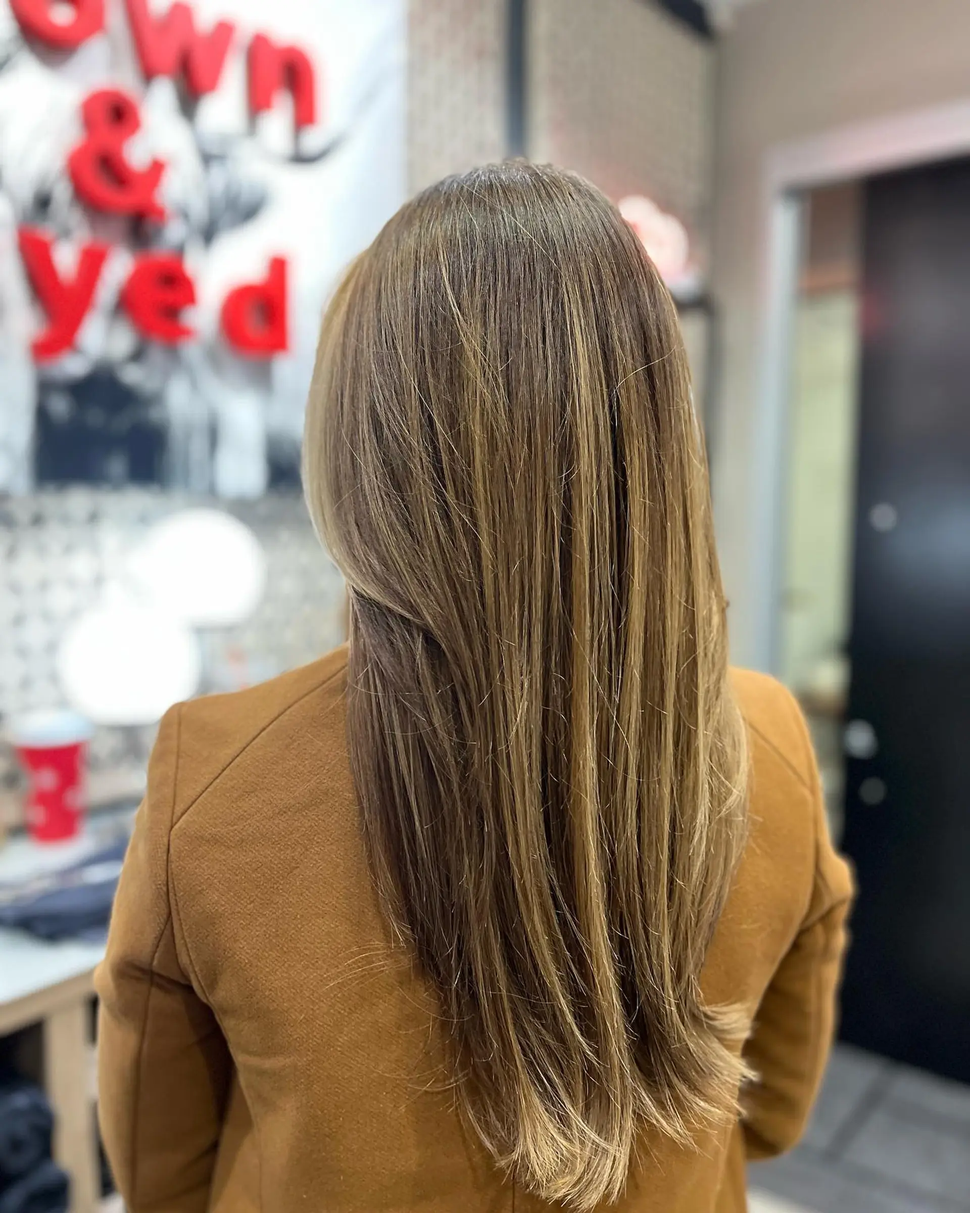 Long, layered straight hair with a honey blonde balayage. 2