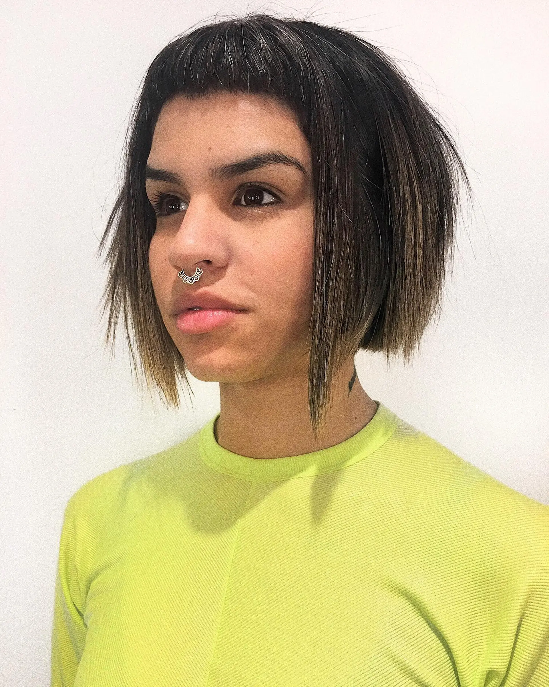 A textured razor bob cut featuring edgy, choppy micro bangs and disconnected face-framing layers. 1