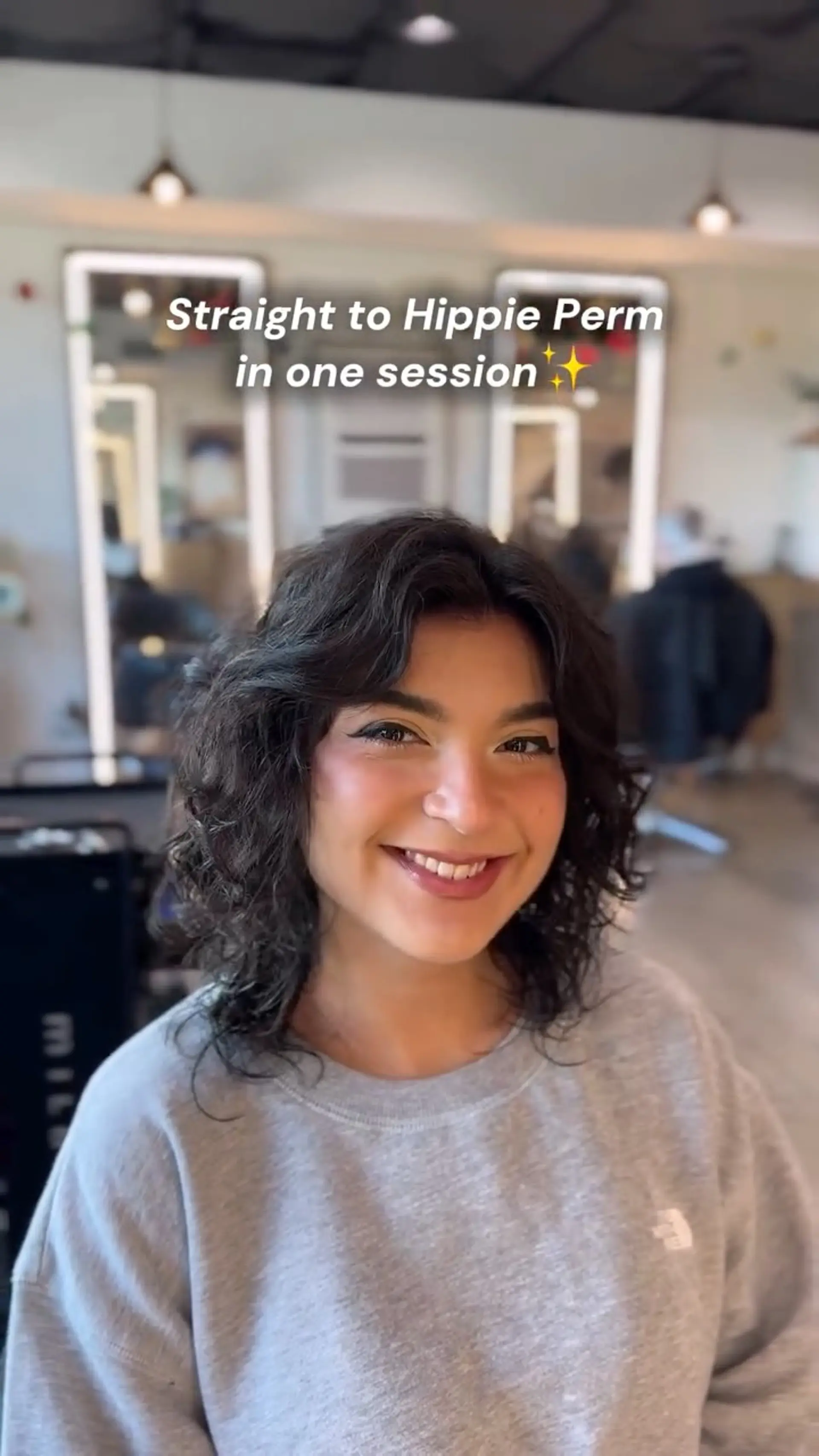Medium-length textured hippie perm featuring bouncy, defined curls with soft face-framing curtain bangs. 1