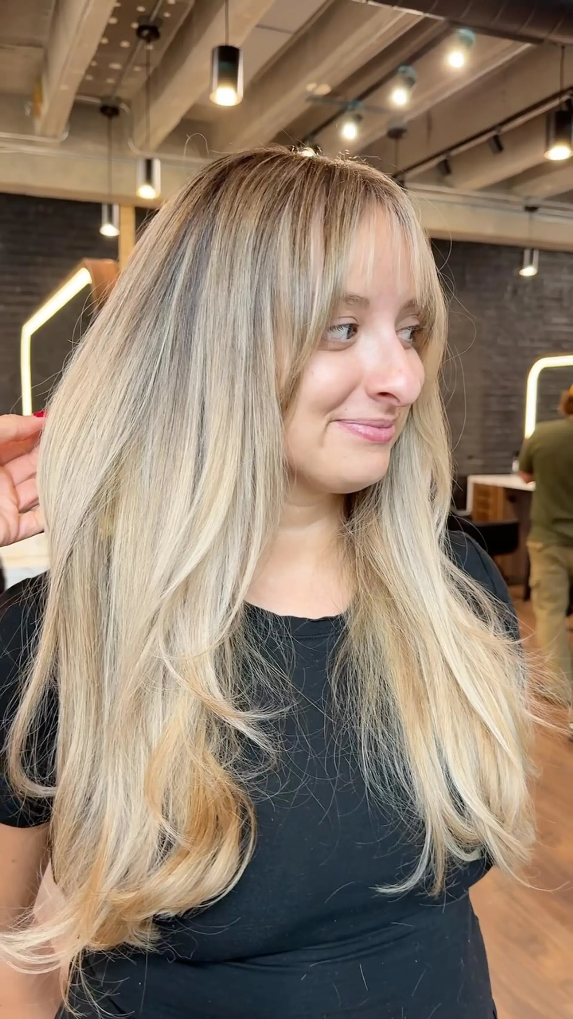 Long dimensional blonde hair featuring soft face-framing layers and light, wispy bangs. 1