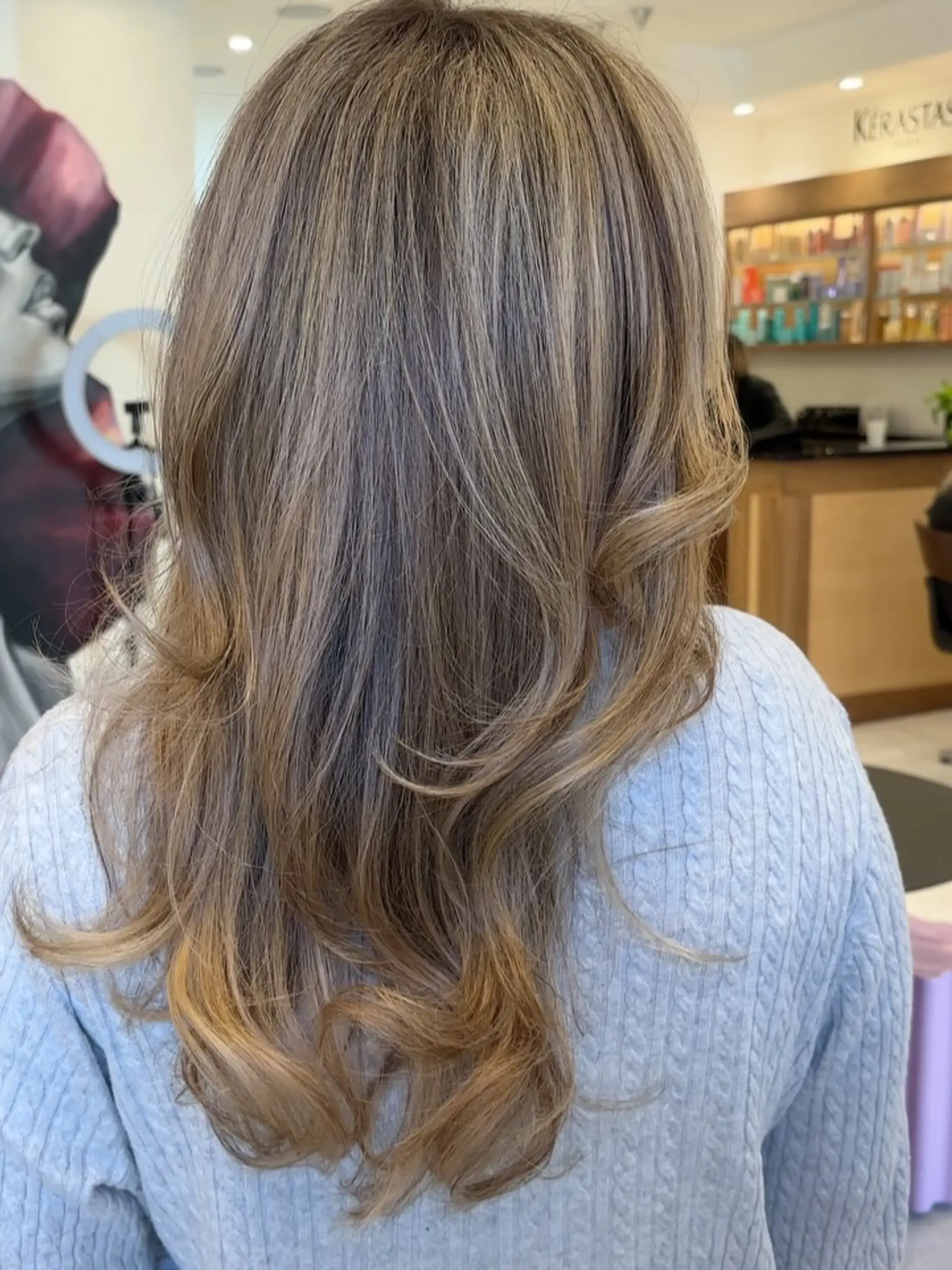 Long layered bronde hair featuring soft dimensional highlights with gently curled, flipped ends. 1