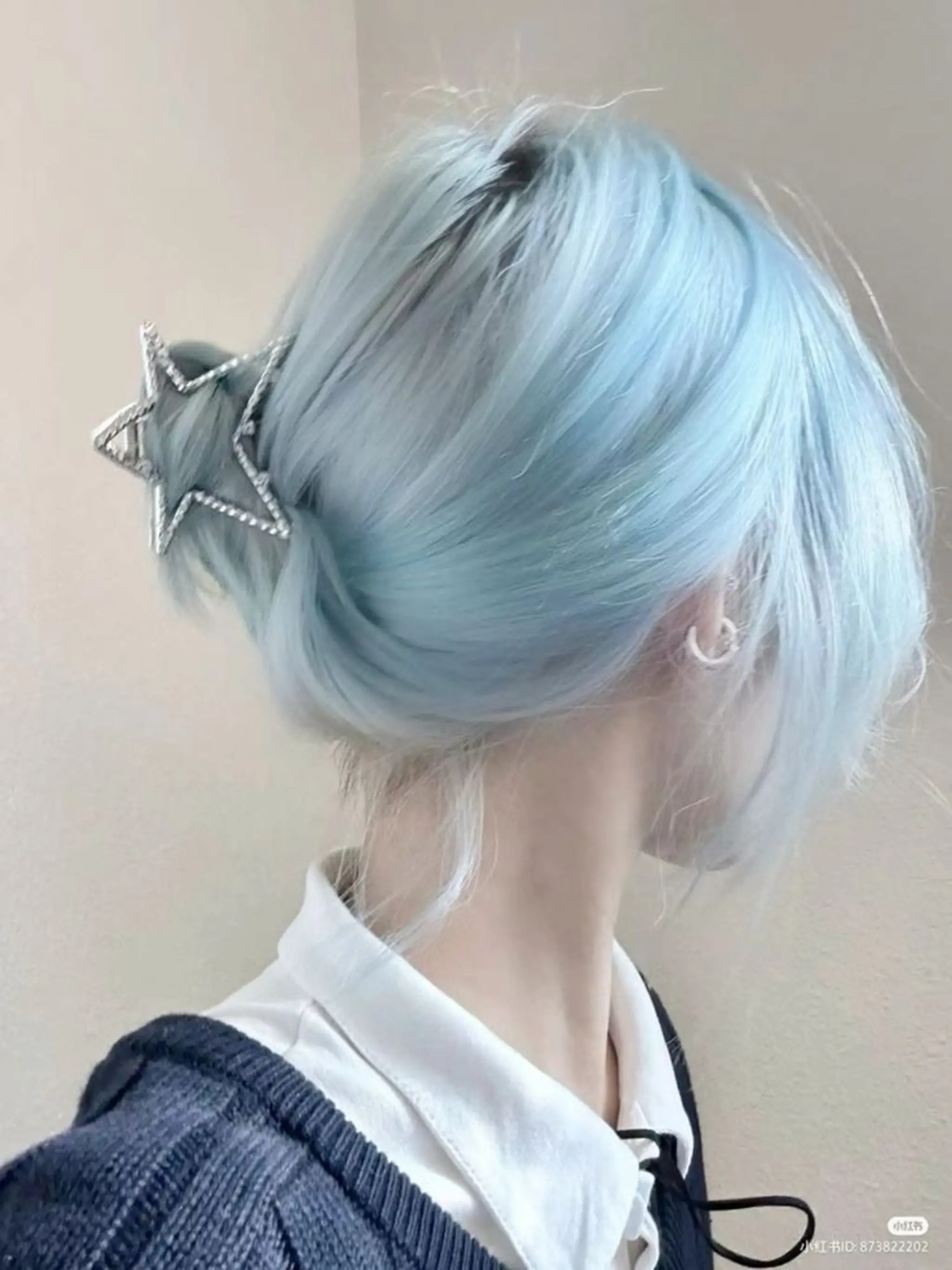 Straight, medium-length hair in a serene bun with pastel blue color, accessorized with a star-shaped piece, and side-swept strands.