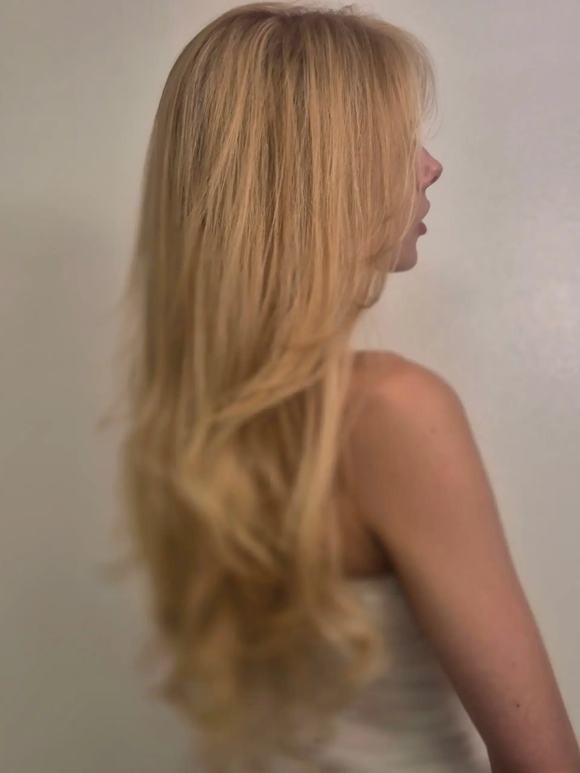 Long warm golden blonde hair styled with soft, cascading layers and light movement. 1
