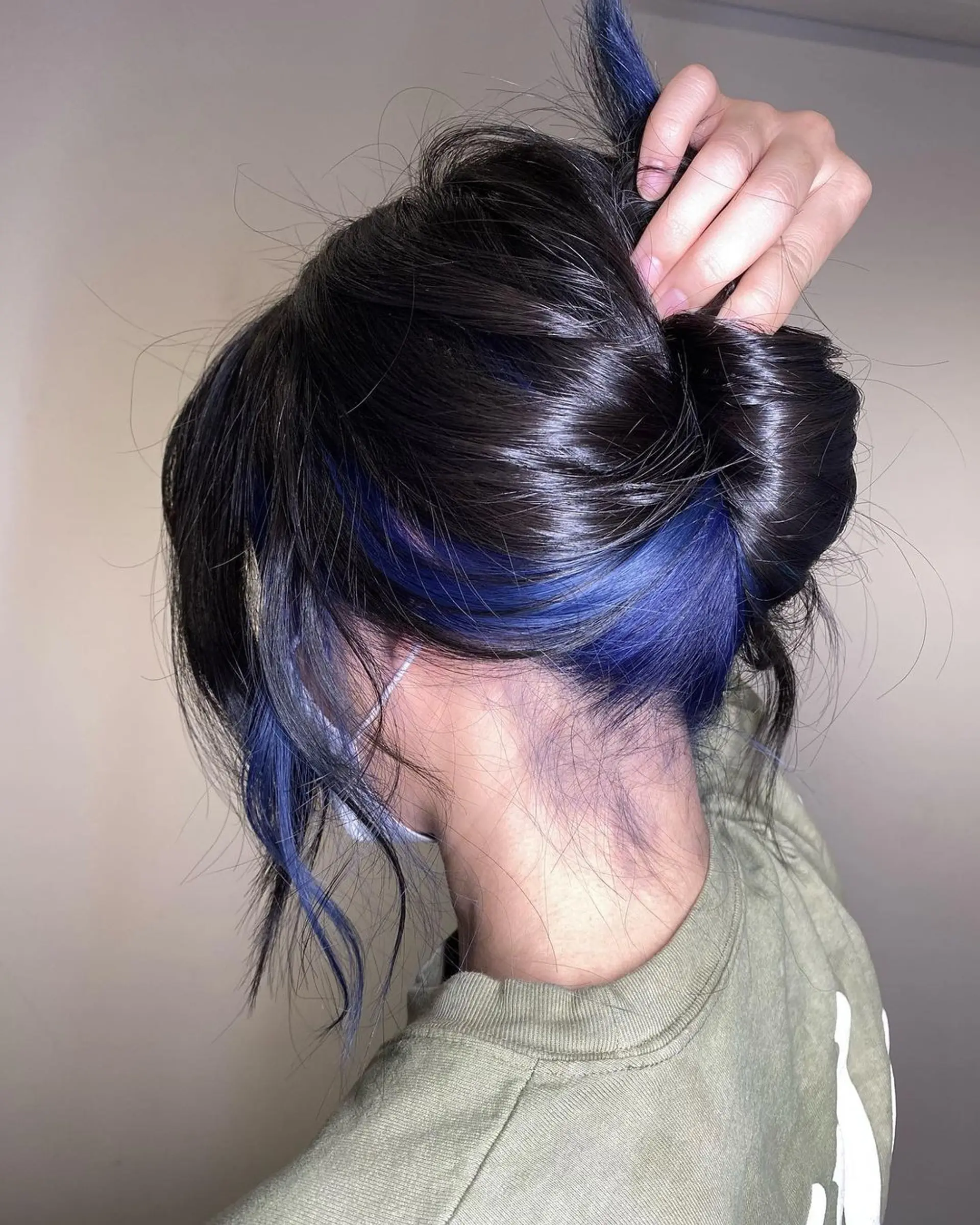 Medium-length wavy hair with black base and blue balayage highlights cascading in textured layers for a lived-in, glamorous look. 3