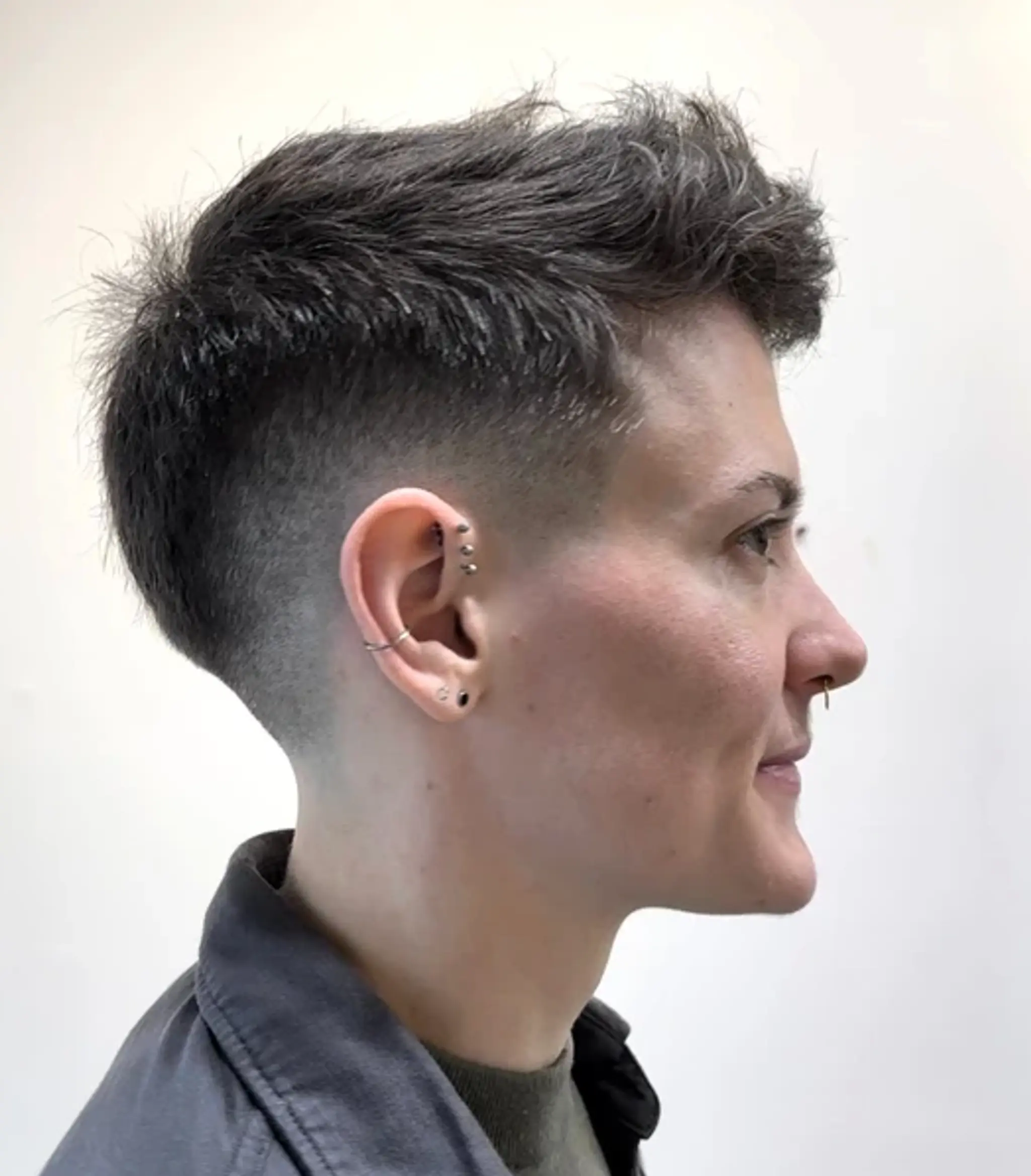 Short, wavy textured top with an undercut and taper fade, styled with a side sweep.