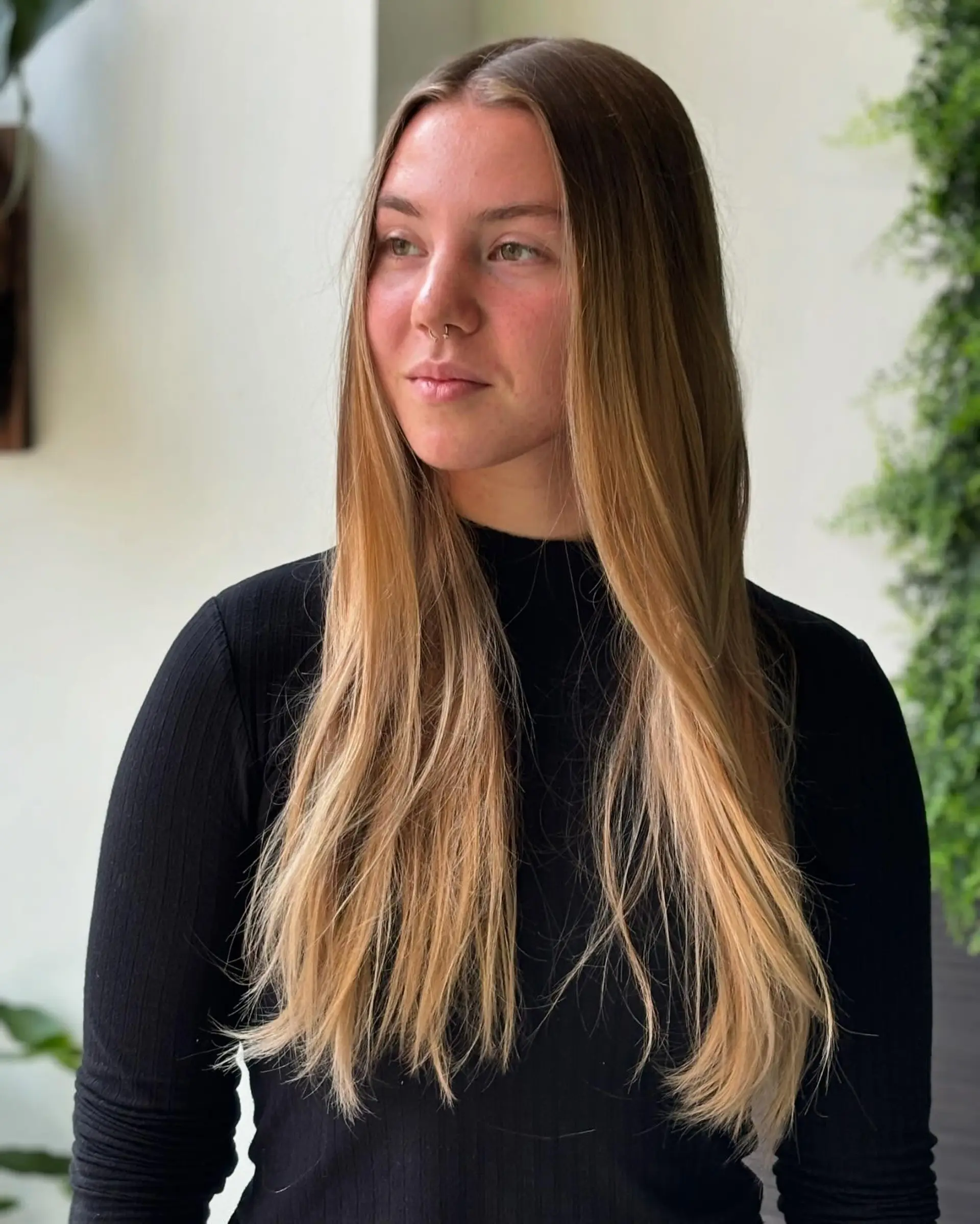 A long, straight hairstyle with a bronzed ombre effect. 2