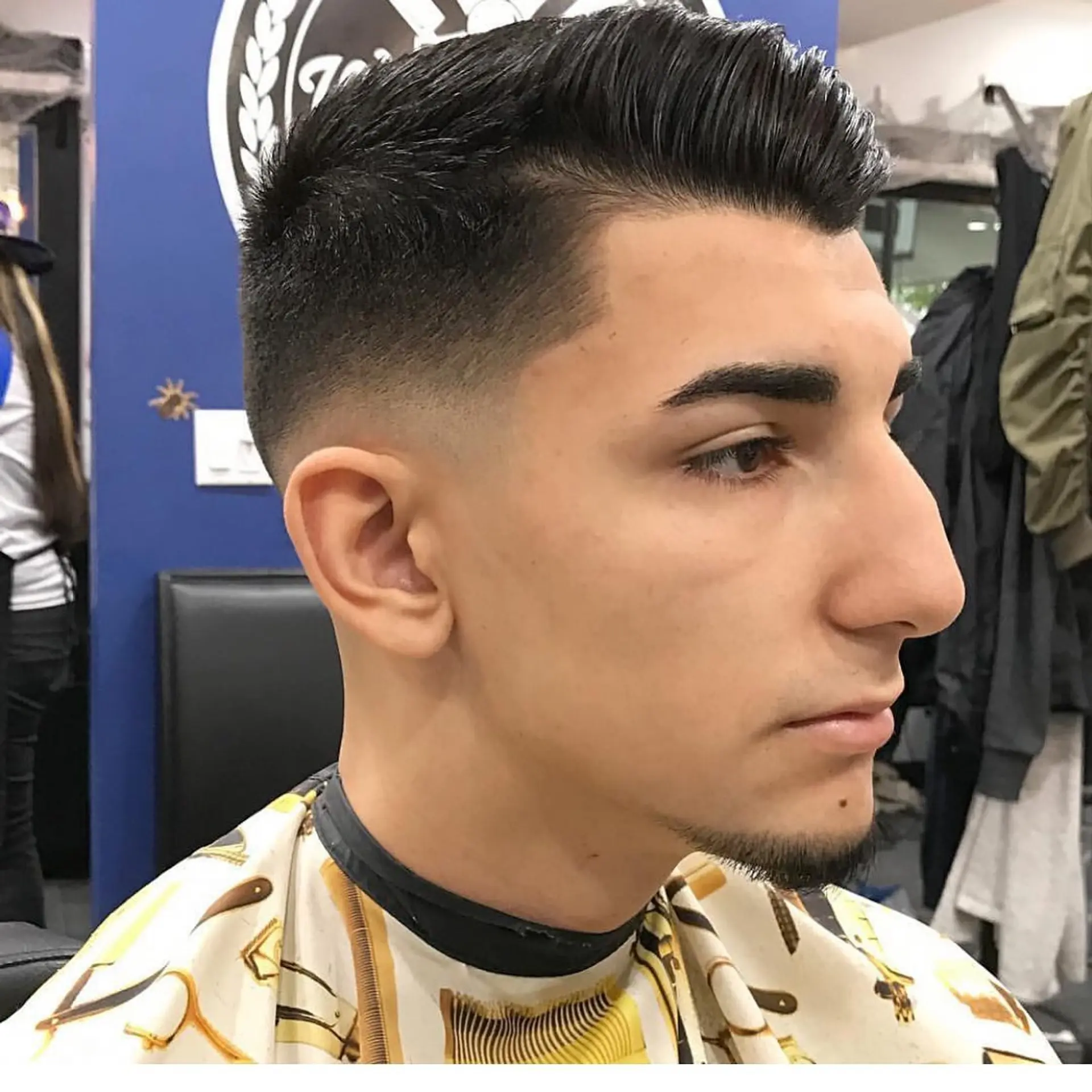 A clean mid skin fade paired with a sleek side-parted comb over and precise line-up. 1