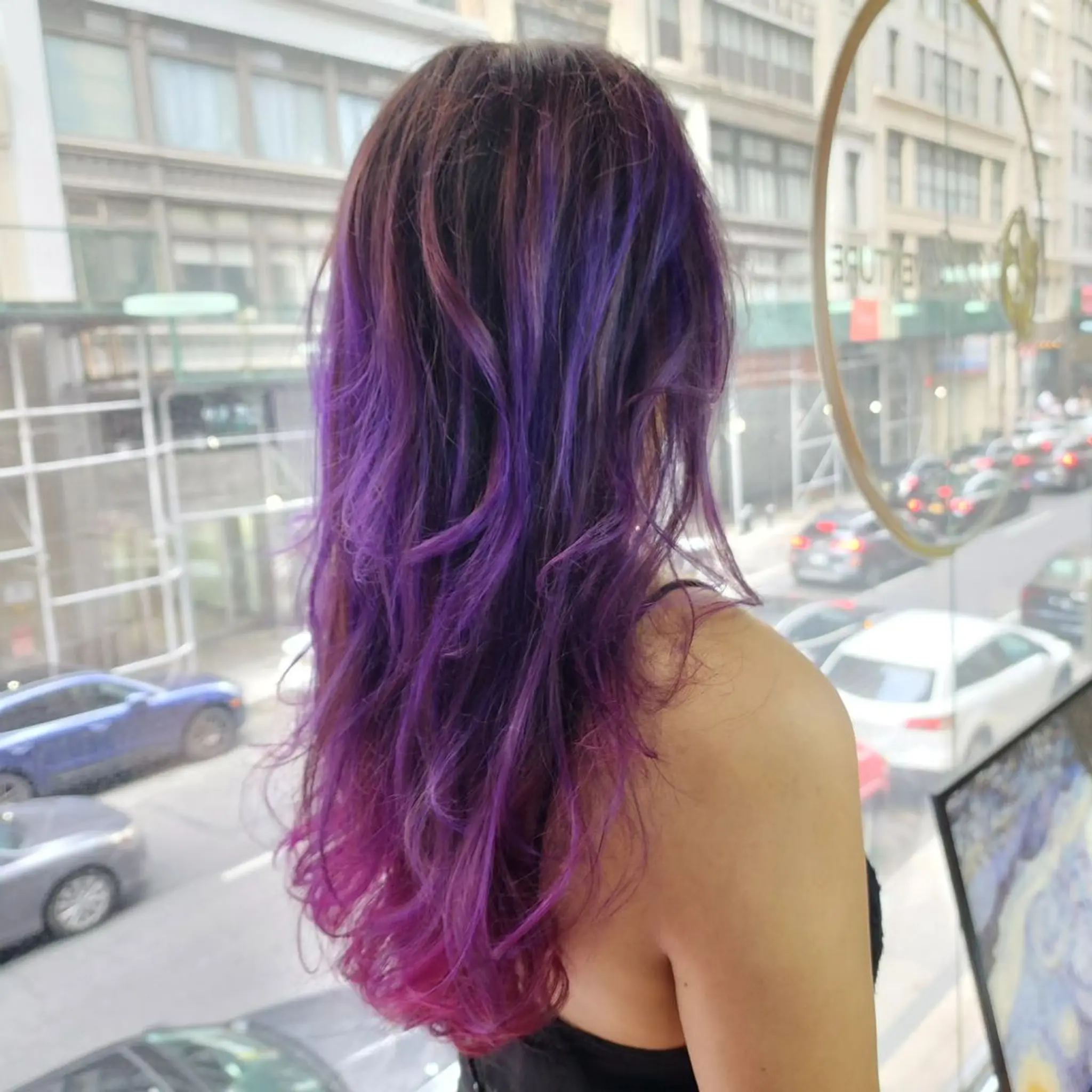 Long, wavy hairstyle with vibrant purple and pink gradients, layered waves, and multi-tonal, dimensional color.