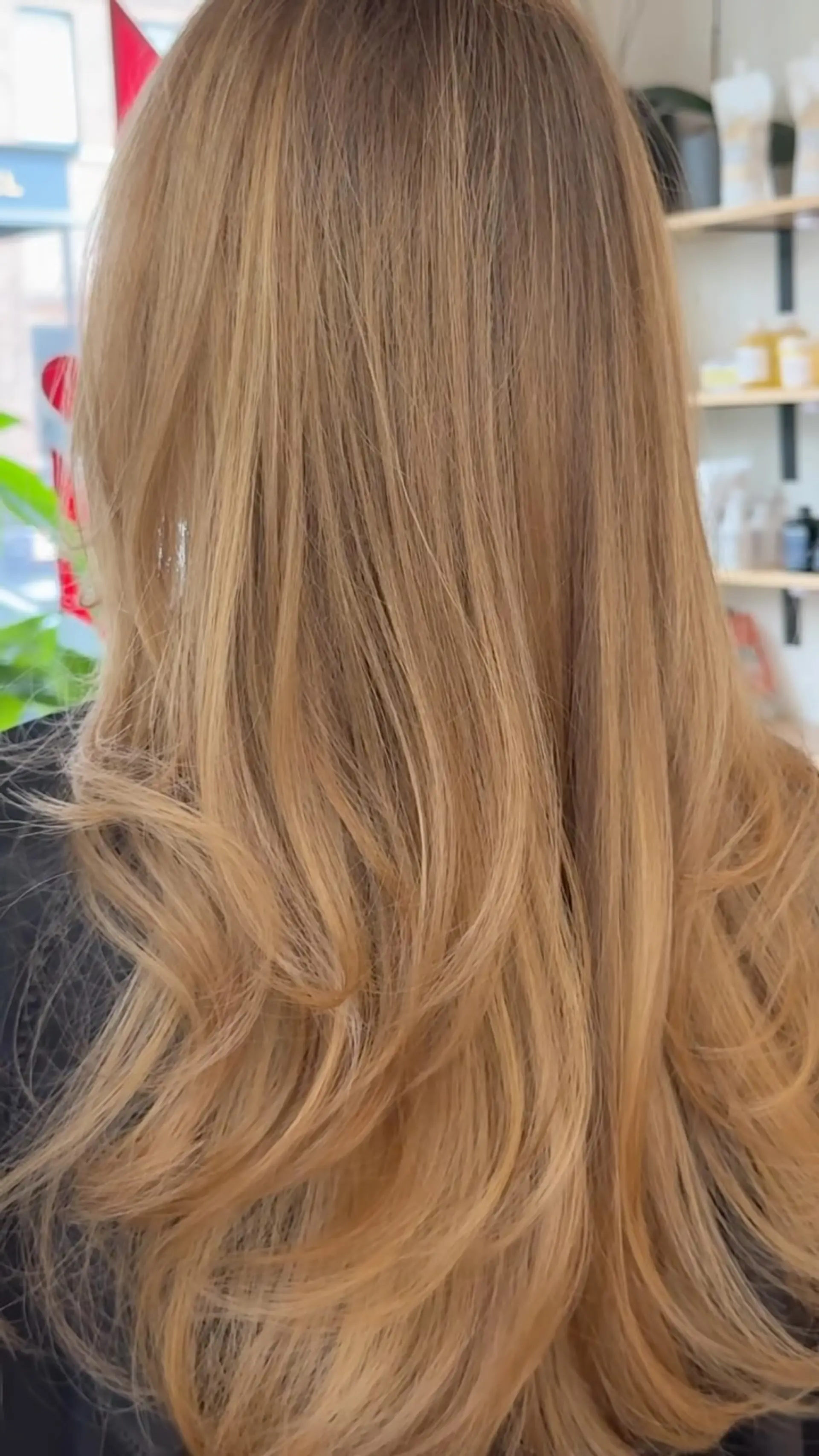 Long warm honey blonde hair featuring soft cascading layers with curled ends. 1