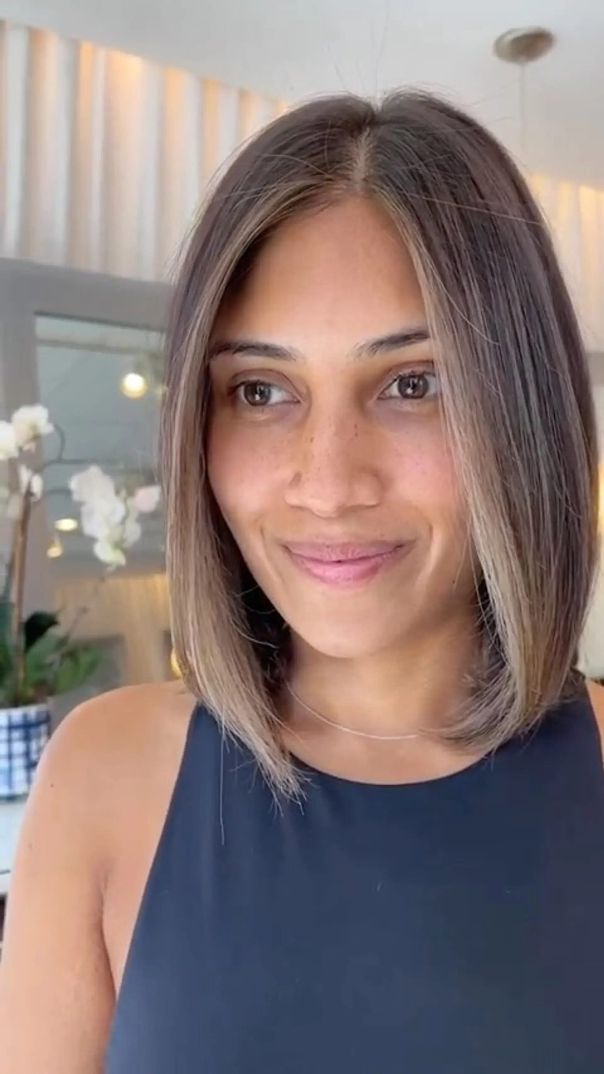 A sleek, shoulder-grazing lob with a center part and soft ash-blonde money piece highlights framing the face. 1