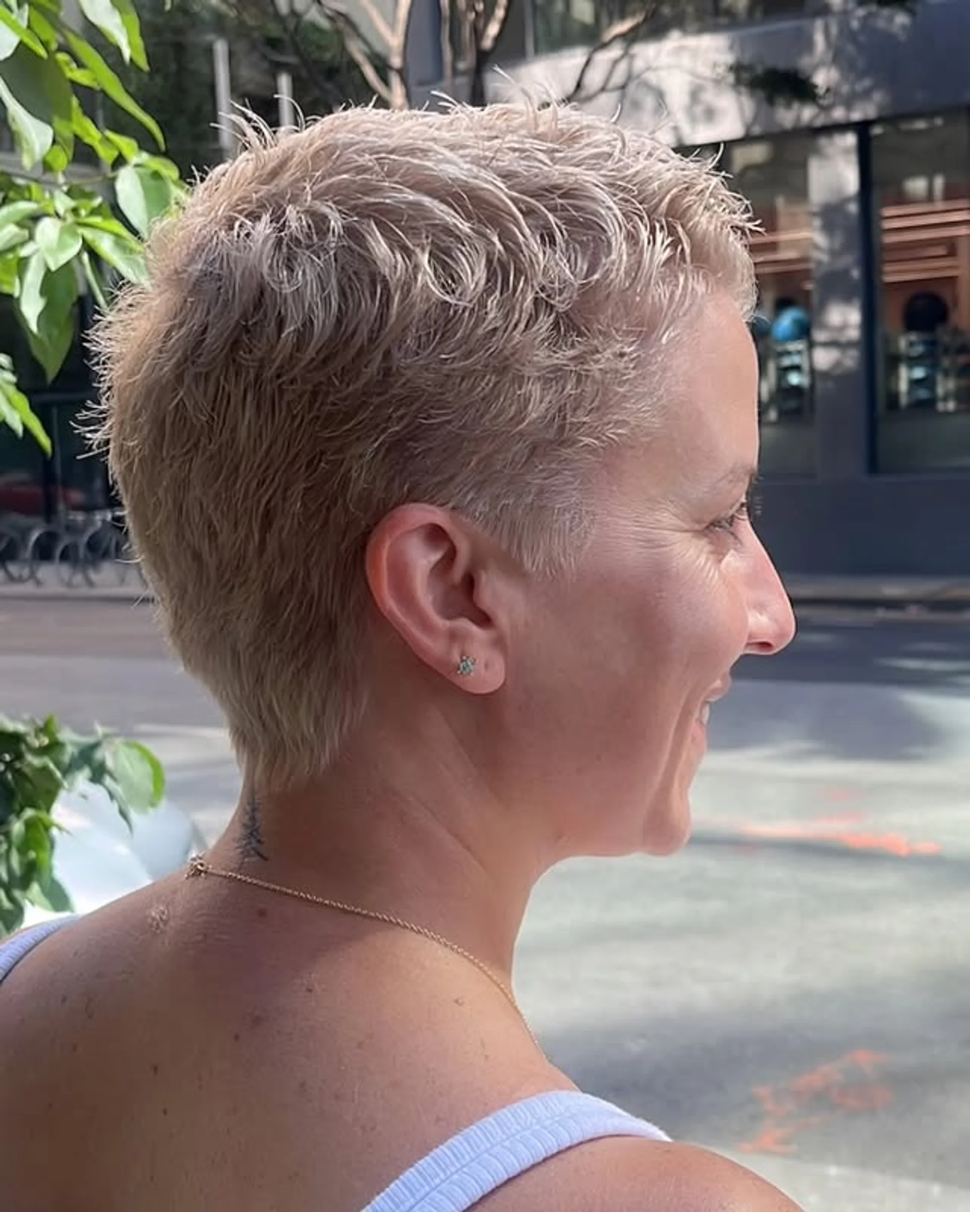 A person with a textured blonde pixie crop, styled with soft, side-swept layers. - Preview 3
